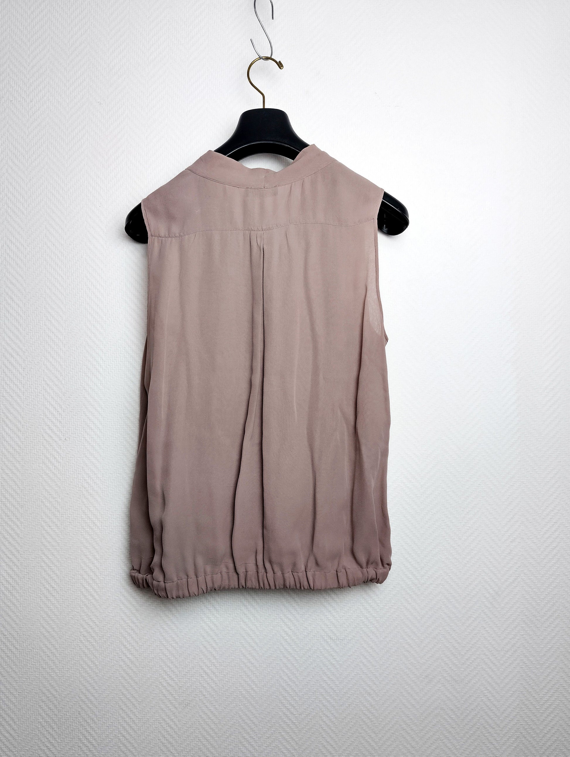 Back view of silk blouse on hanger