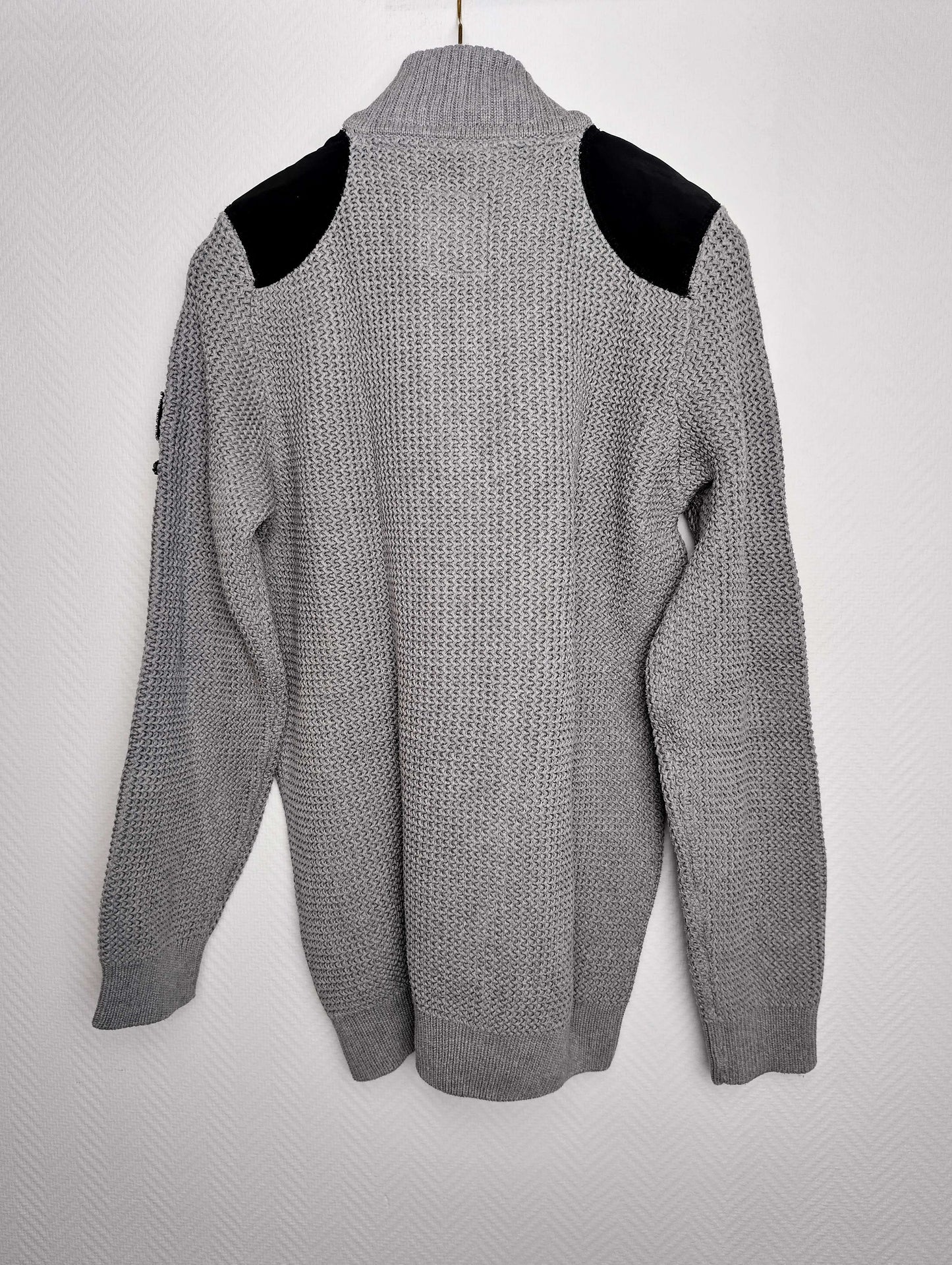 Back view of gray sweater with black shoulder accents
