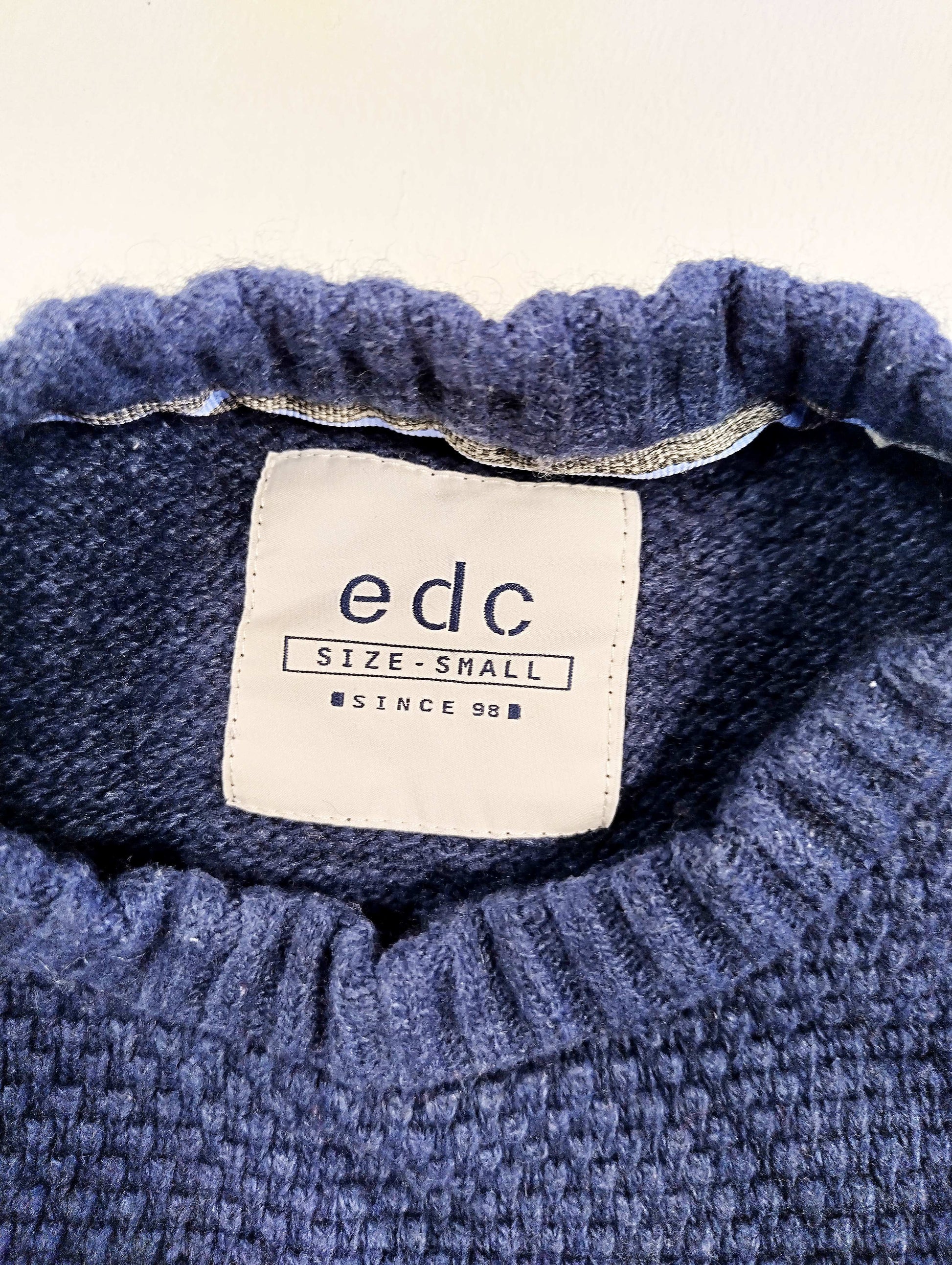 Close-up of sweater tag with brand and size