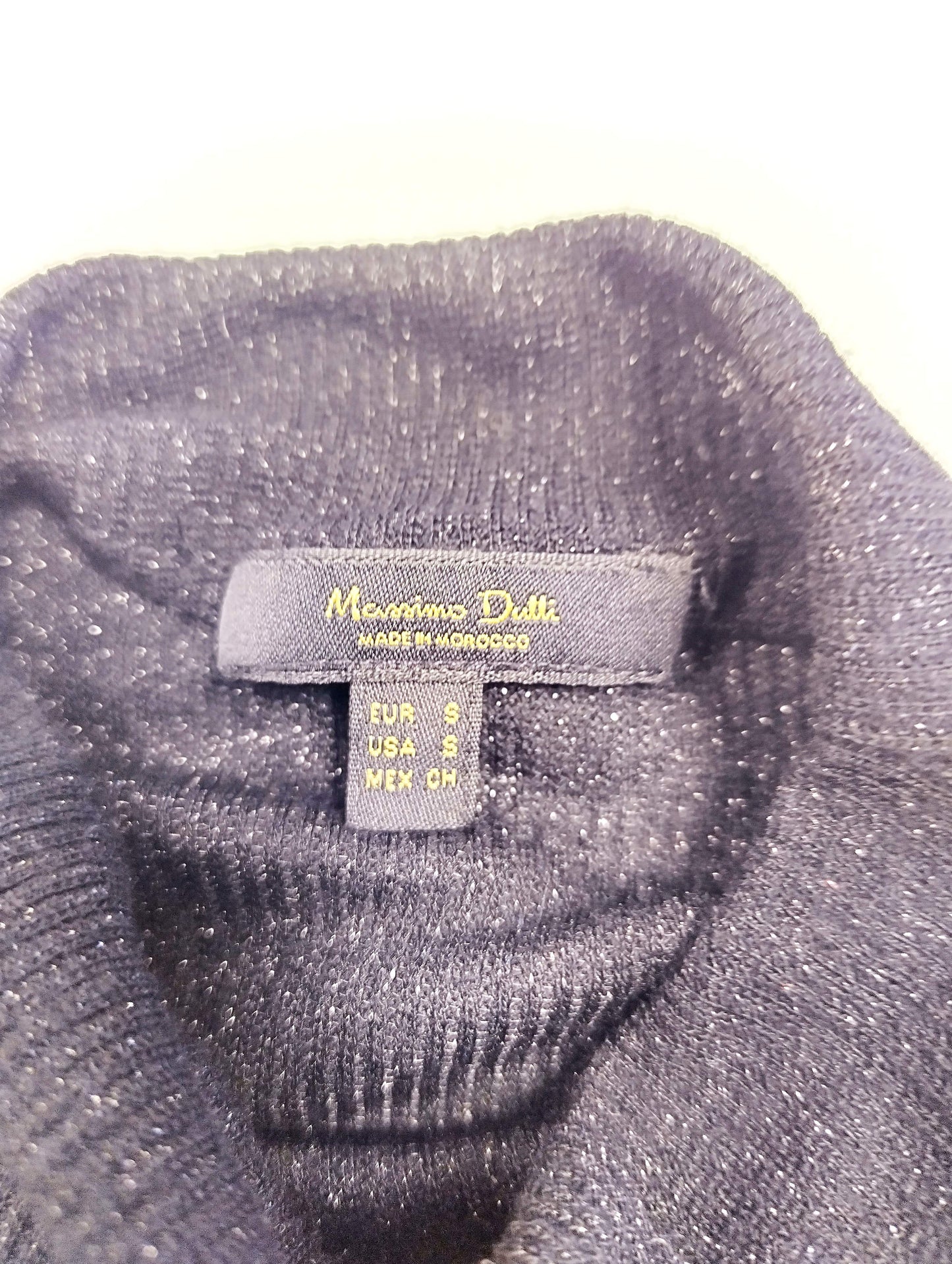 Label on the inside of black long sleeve top