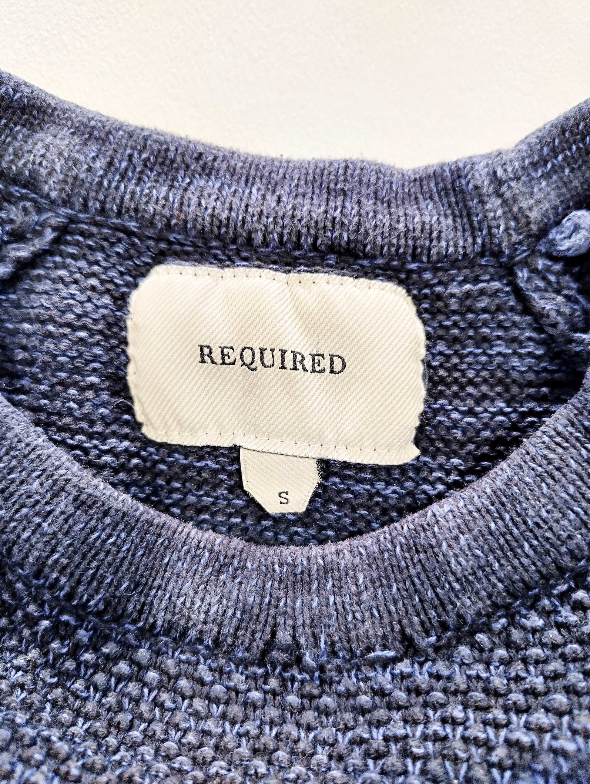 Close-up of sweater label showing size and brand