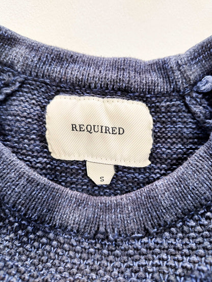 Close-up of sweater label showing size and brand