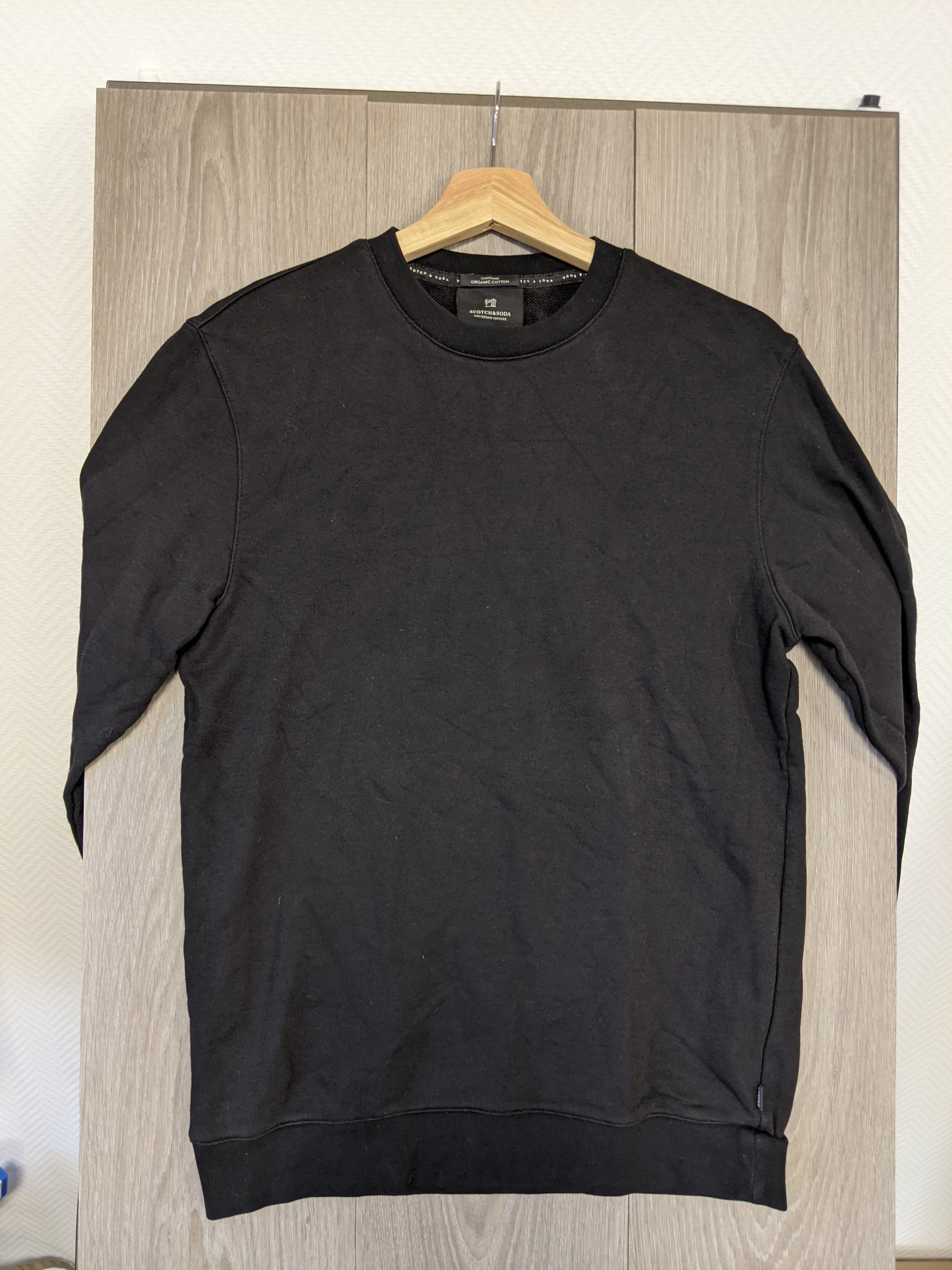 Front view of black sweater hanging