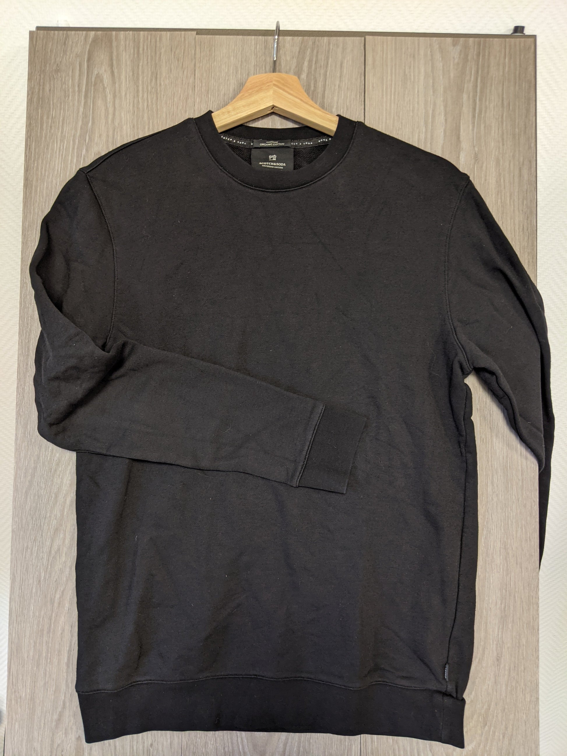 Side view of black sweater hanging
