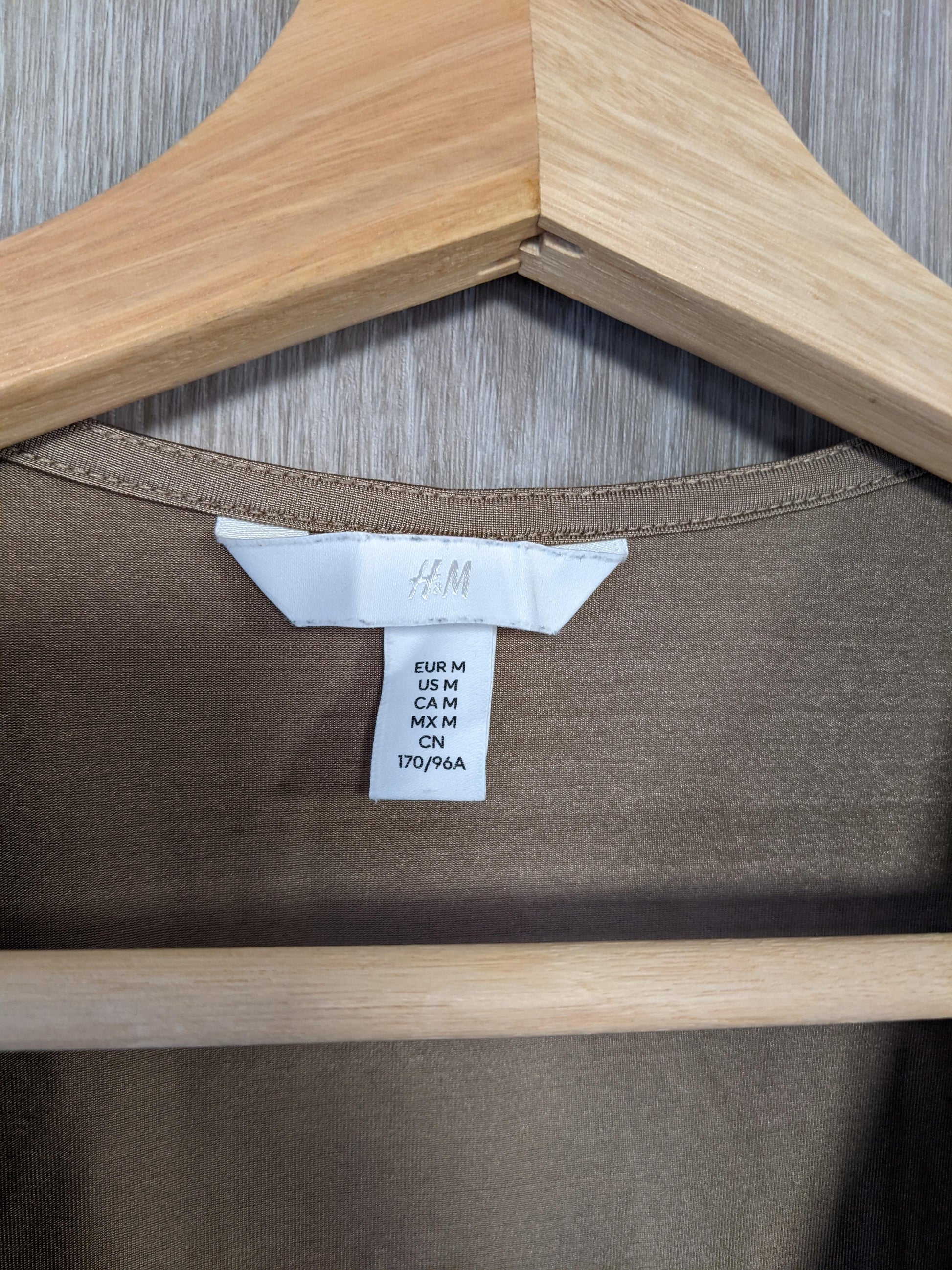 Close-up of size tag on brown bodysuit