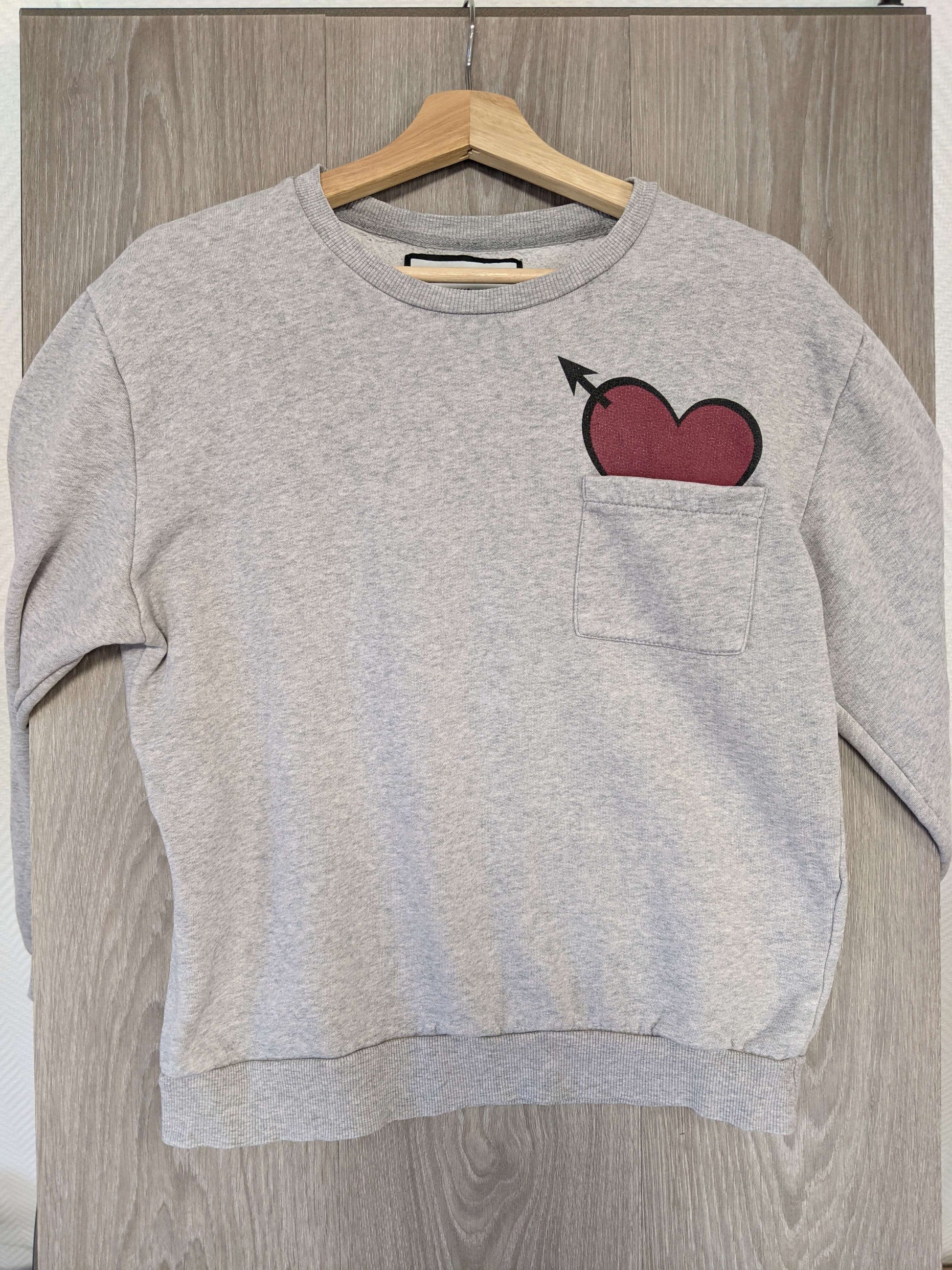 Front view of grey sweater with heart design