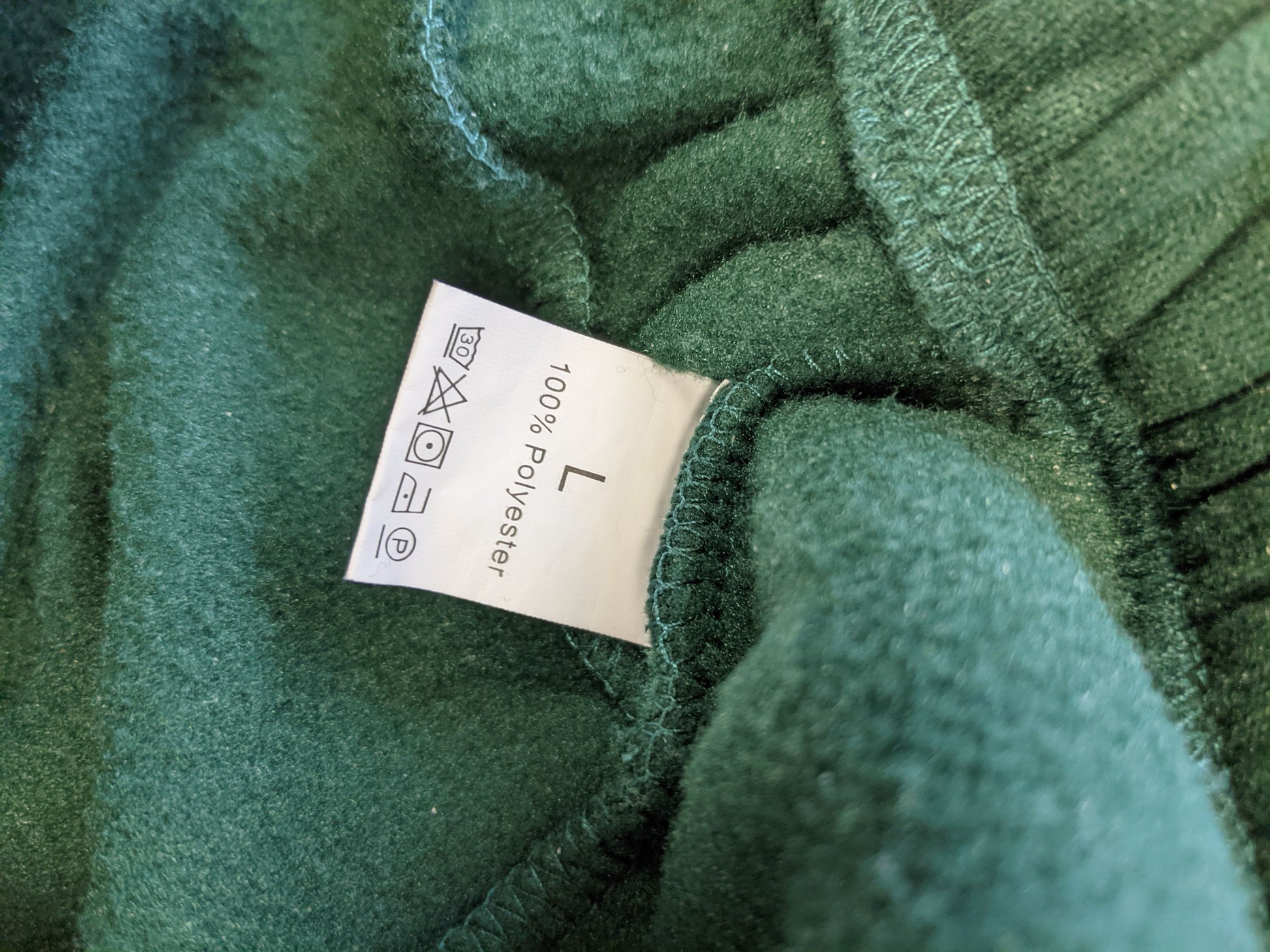 Label of green hoodie showing size and material