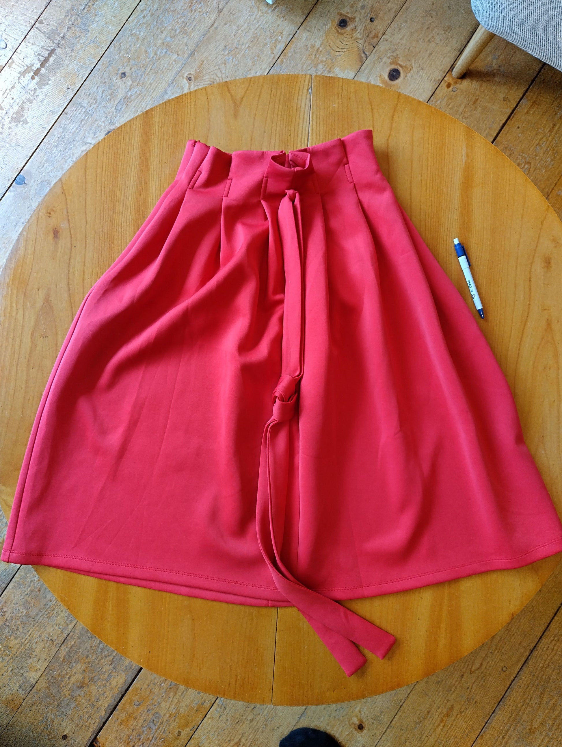 Red midi skirt flat lay view on a wooden table