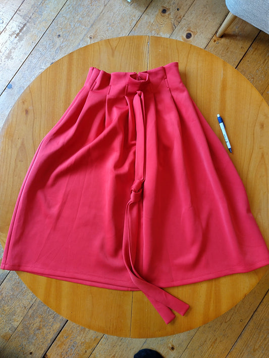 Red midi skirt flat lay view on a wooden table