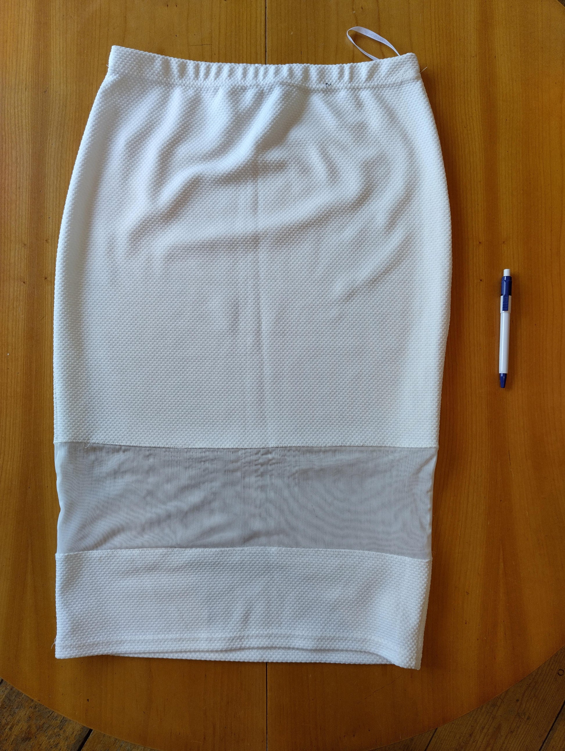 White skirt laid flat on wooden table