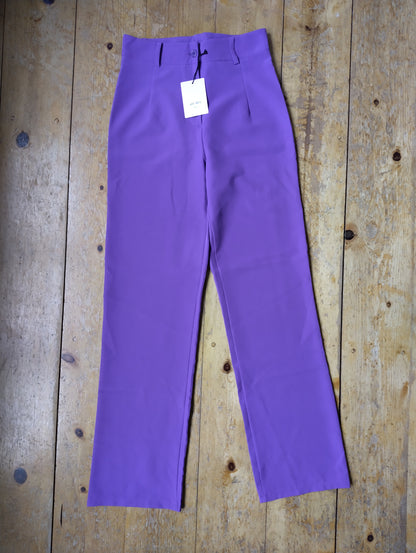 Purple wide-leg trousers on wooden floor