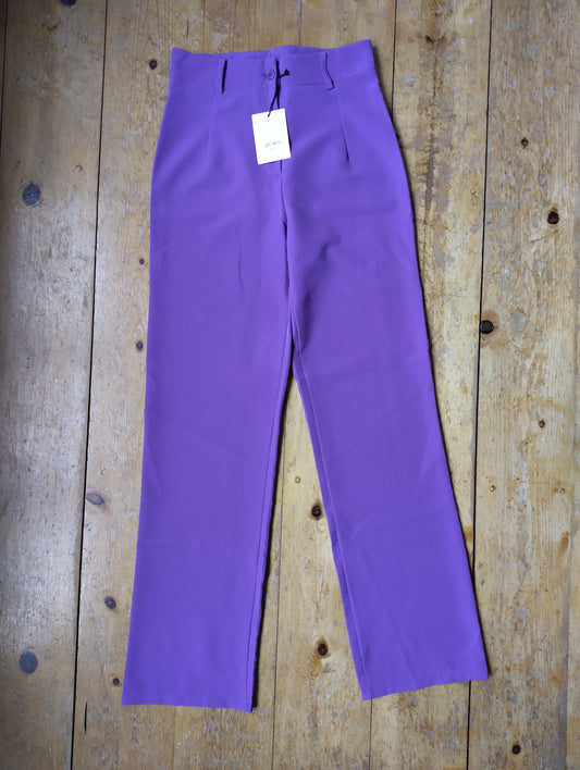 Purple wide-leg trousers on wooden floor
