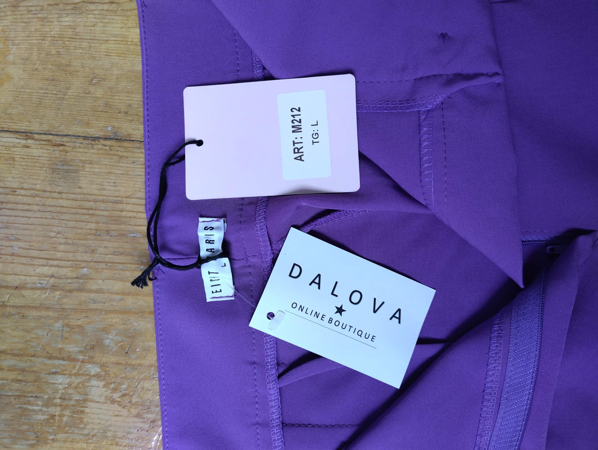 Close-up of tag on purple trousers