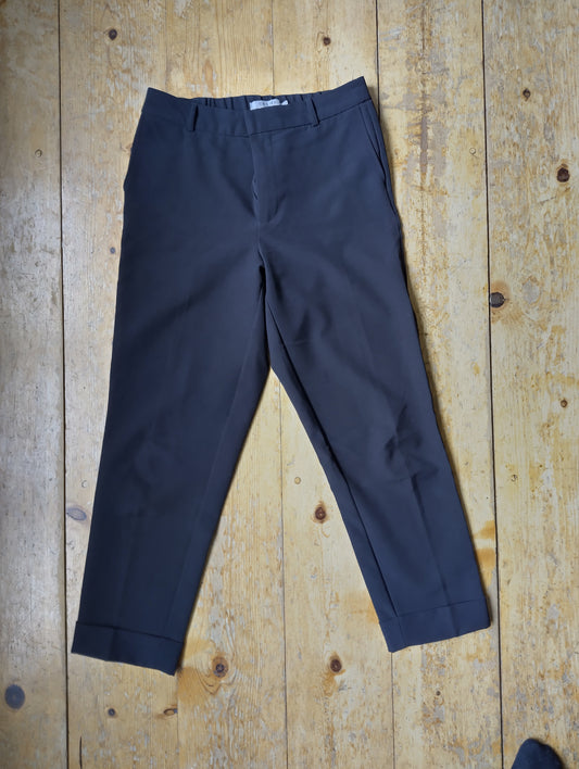 Black Costes chinos on wooden surface