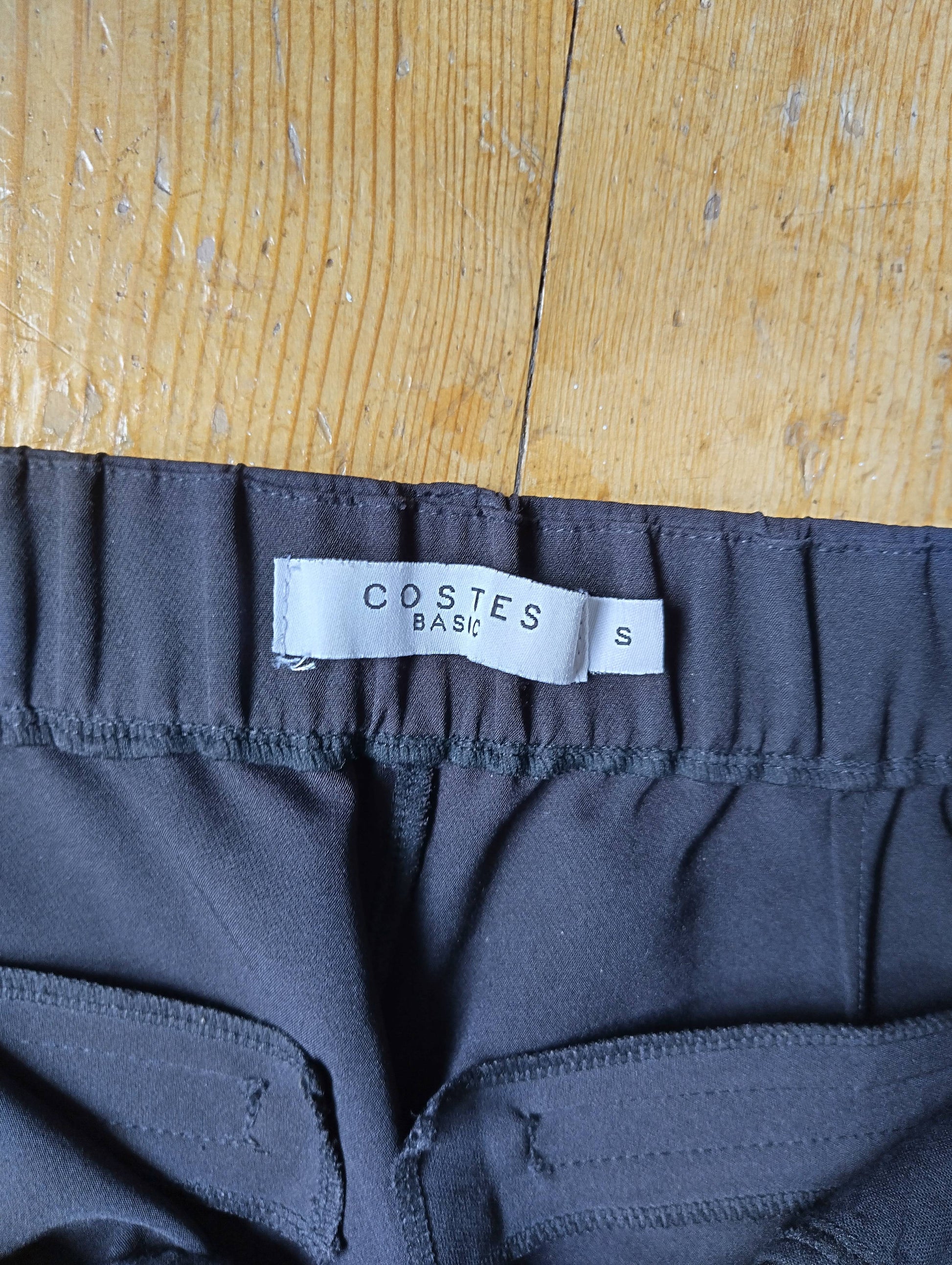 Close-up of Costes label on black chinos