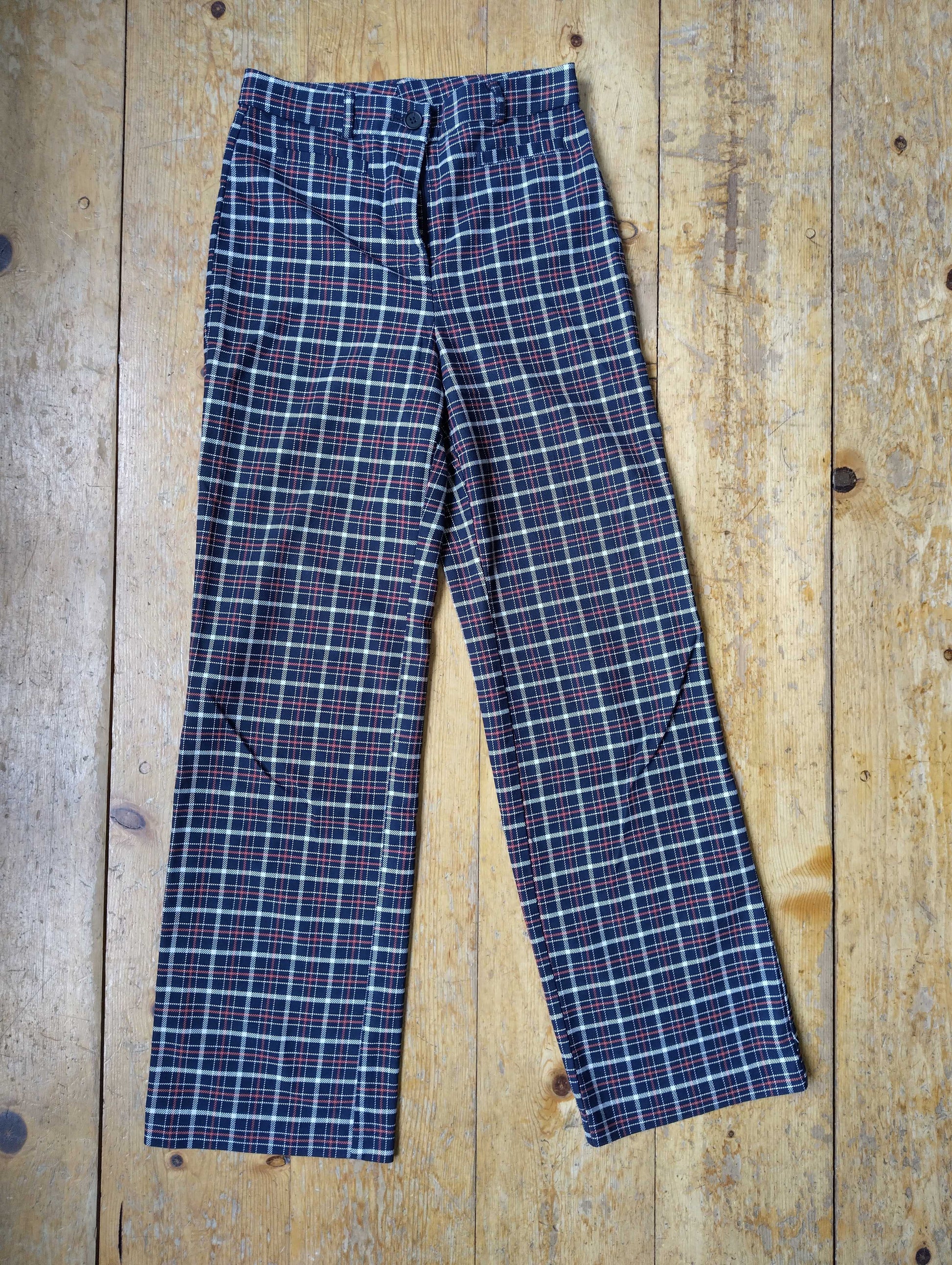 Red plaid straight leg pants on wooden floor