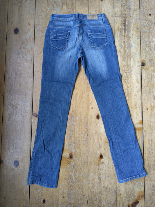 Back view of blue jeans on wooden floor