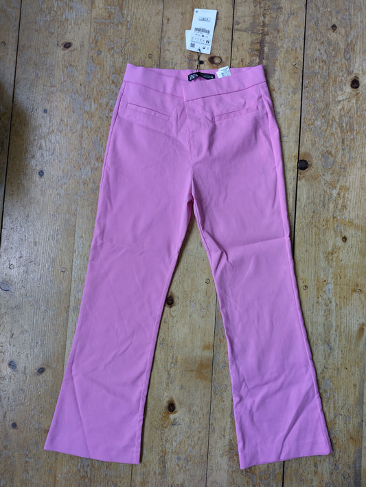 Pink flare pants on a wooden surface