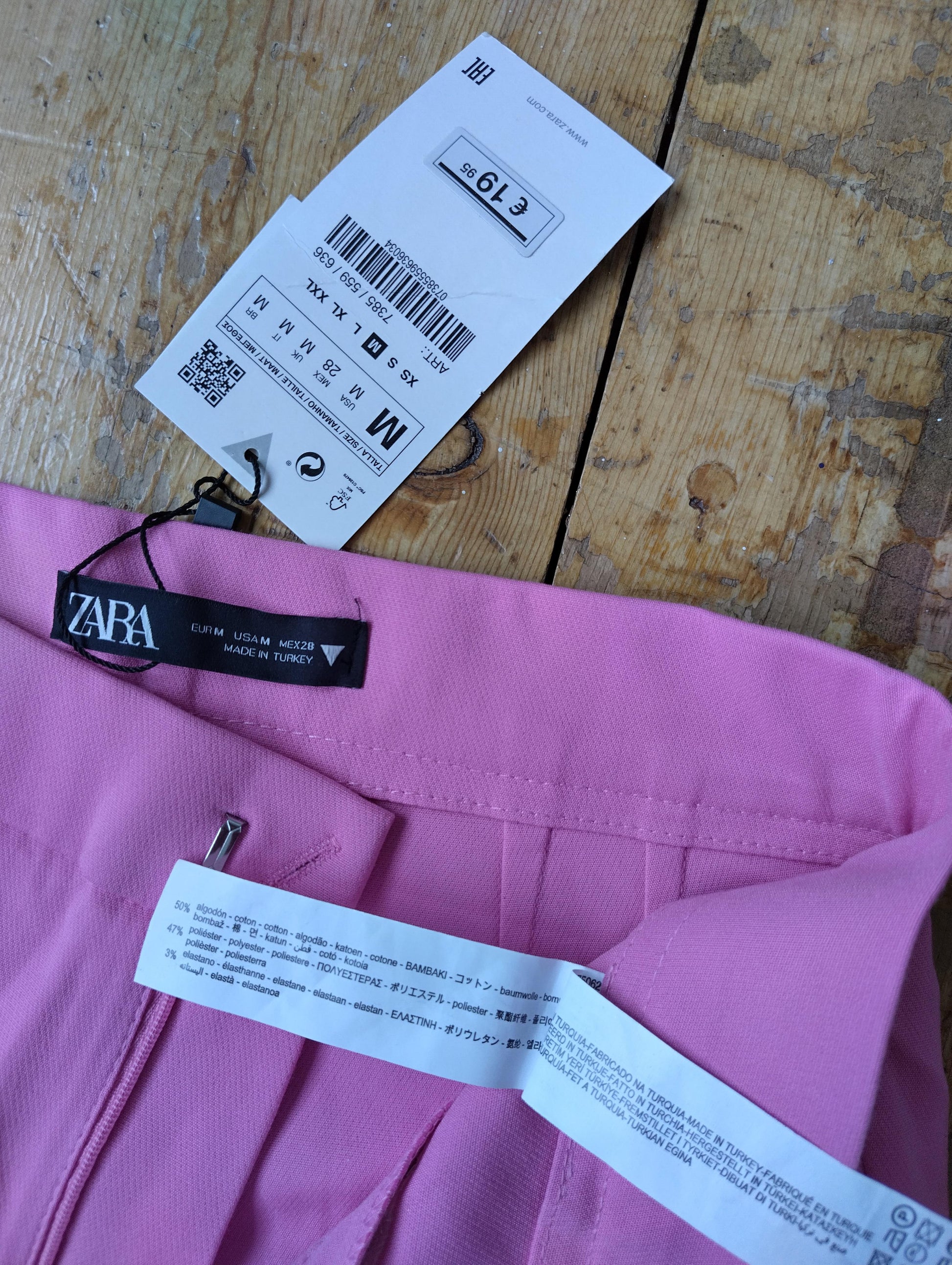 Close-up of Zara label and tags on pink pants