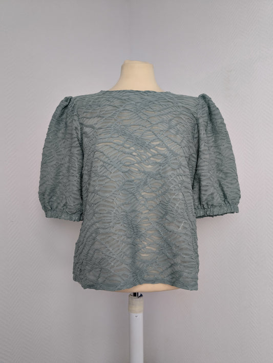 Front view of sage green lace blouse on mannequin