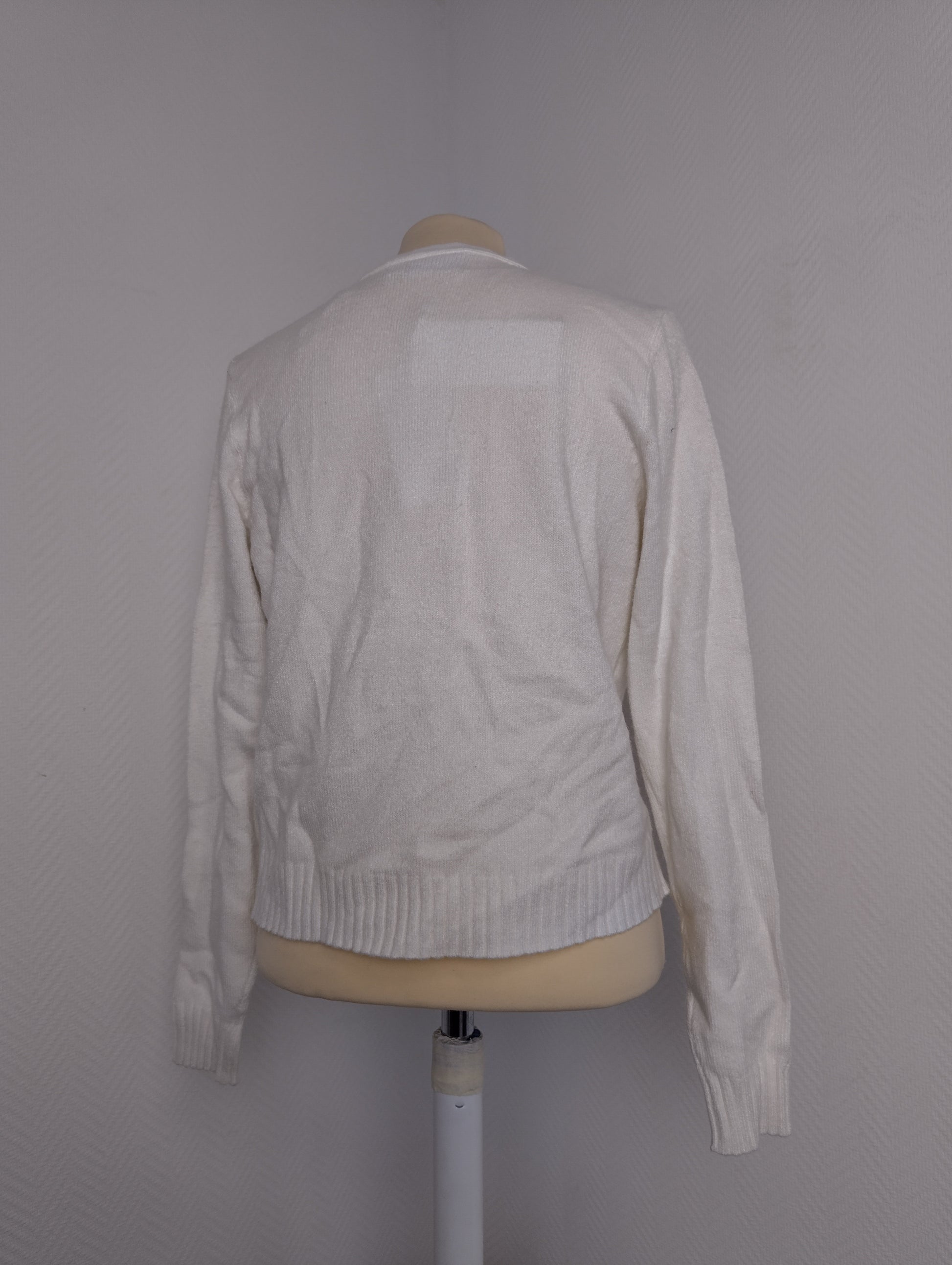 Back view of white cardigan on mannequin