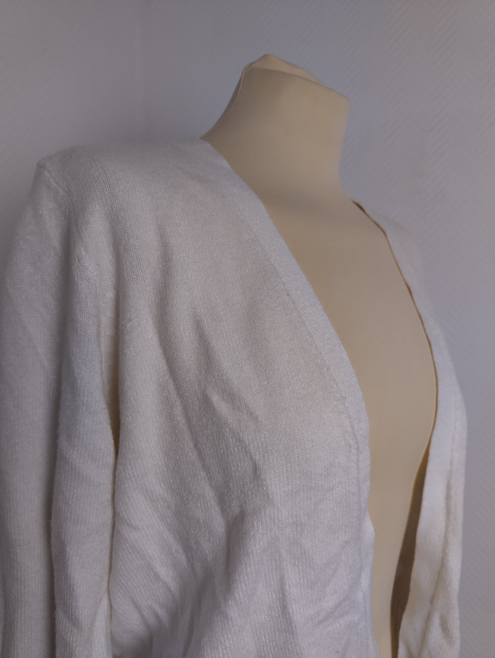 Side angle of white cardigan on mannequin