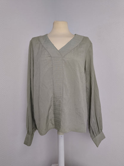 Front view of green long-sleeve blouse on mannequin