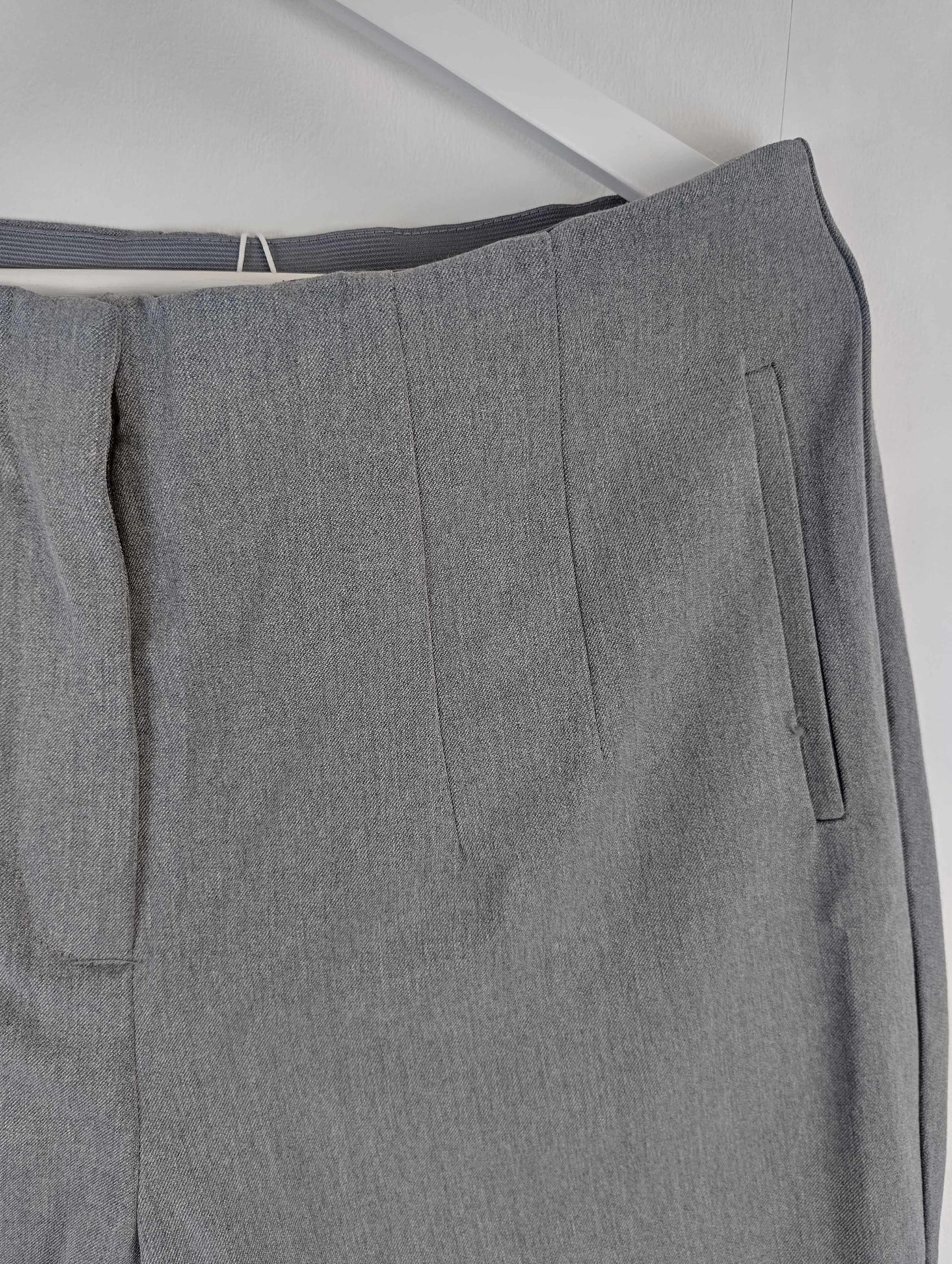 Side detail of grey pants on hanger