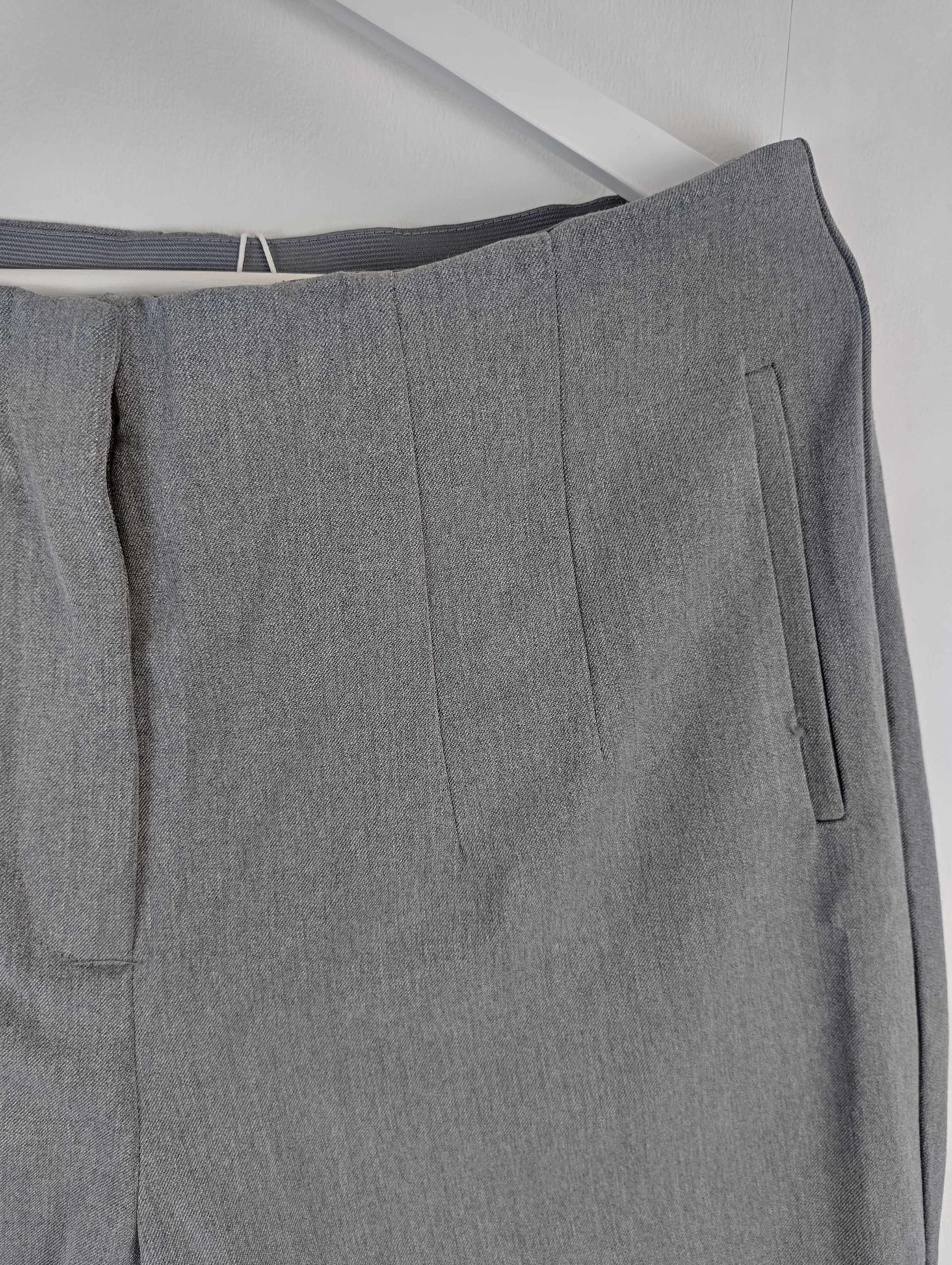Side detail of grey pants on hanger