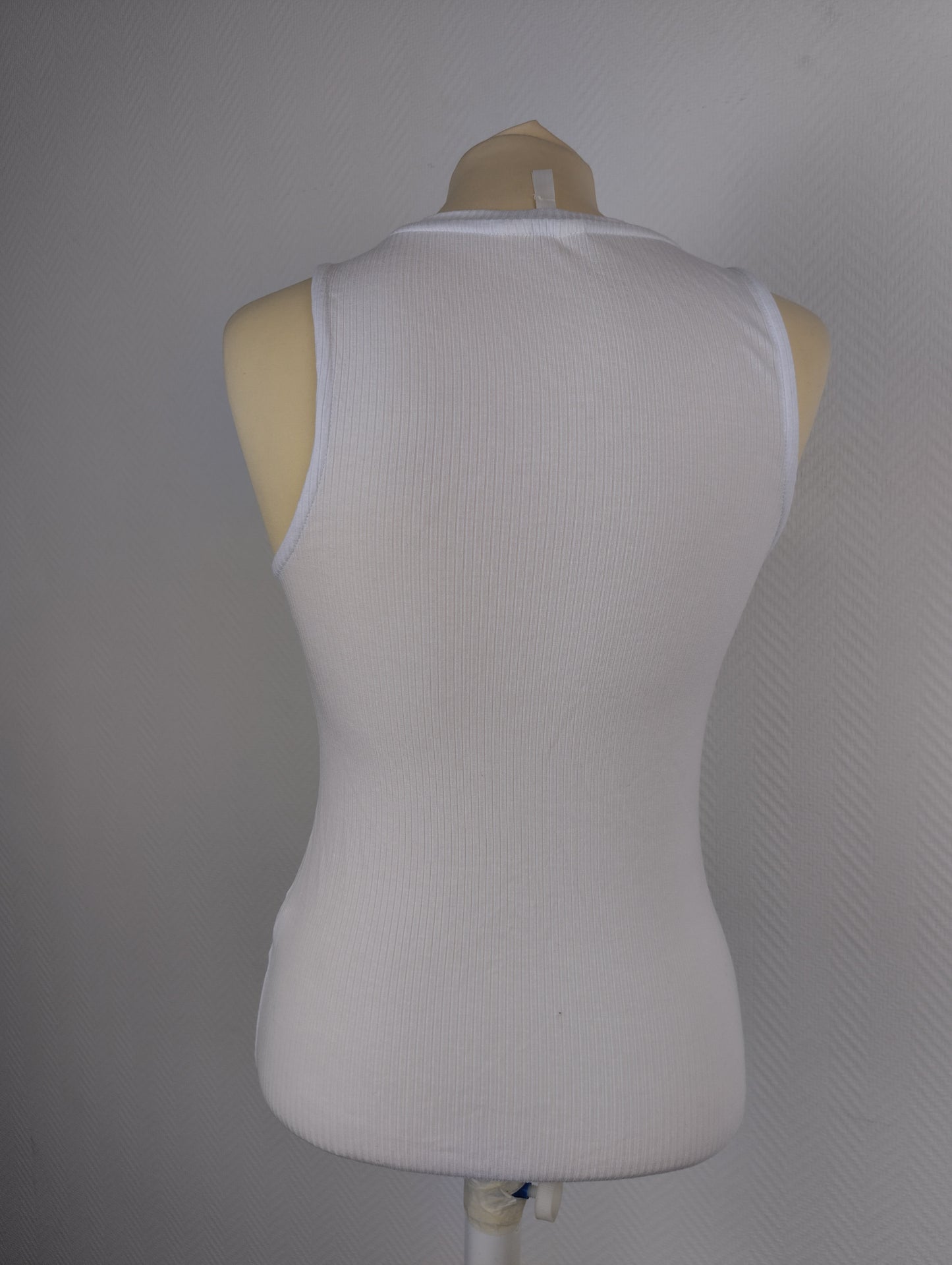Back view of white ribbed tank top on mannequin