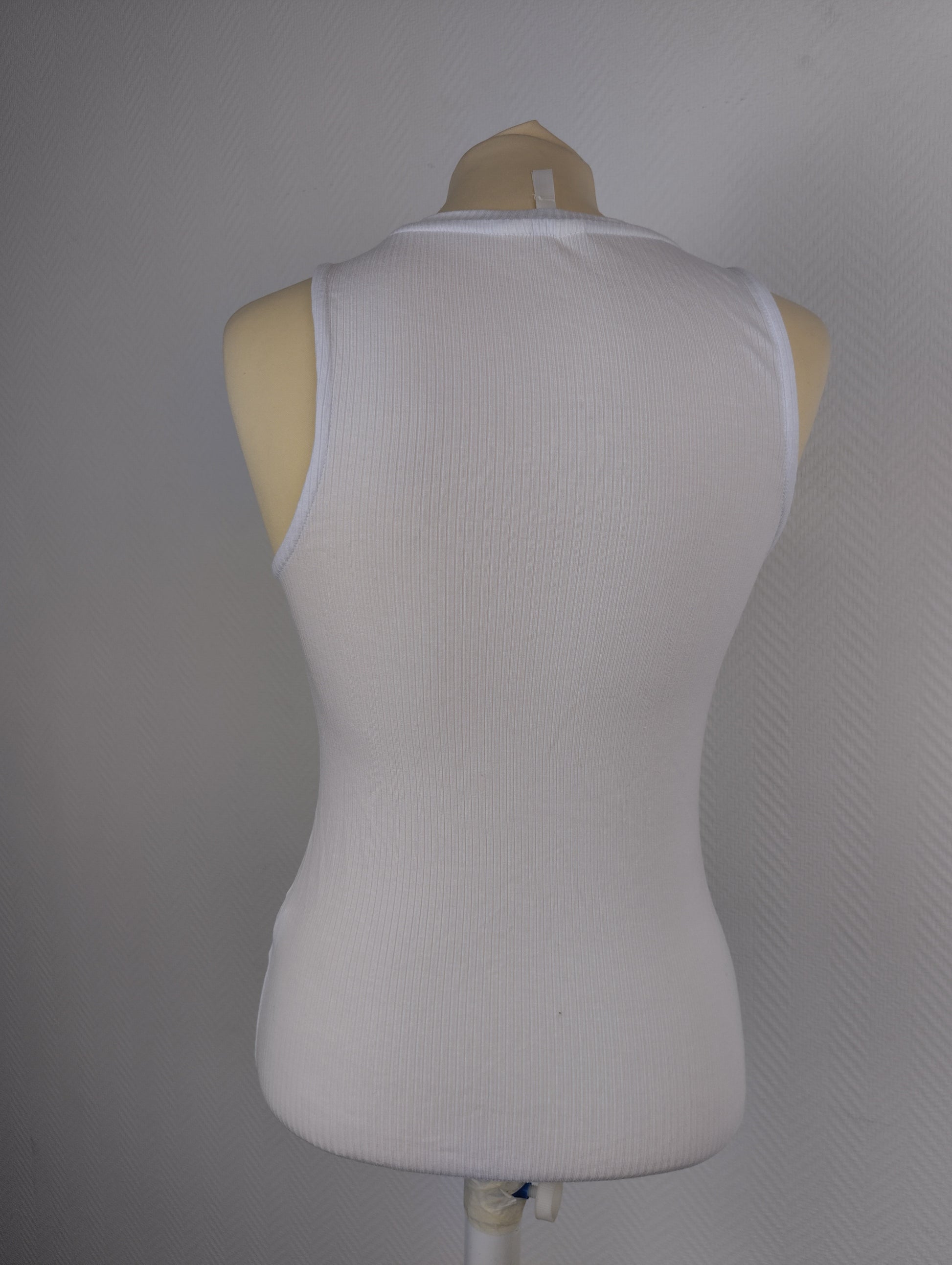 Back view of white ribbed tank top on mannequin