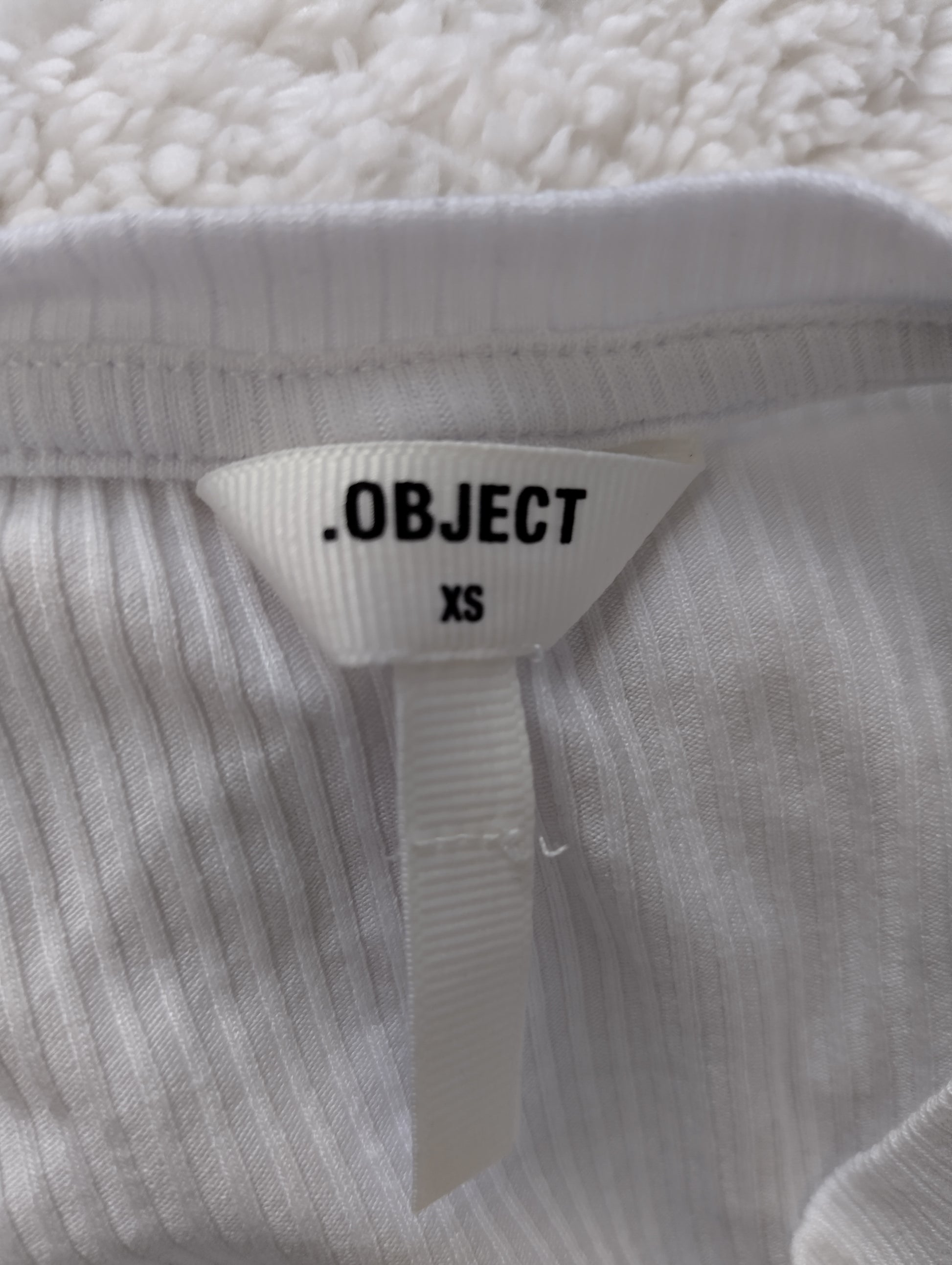 Label showing brand and size of the white ribbed tank top