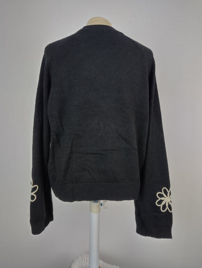Back view of black sweater with floral design