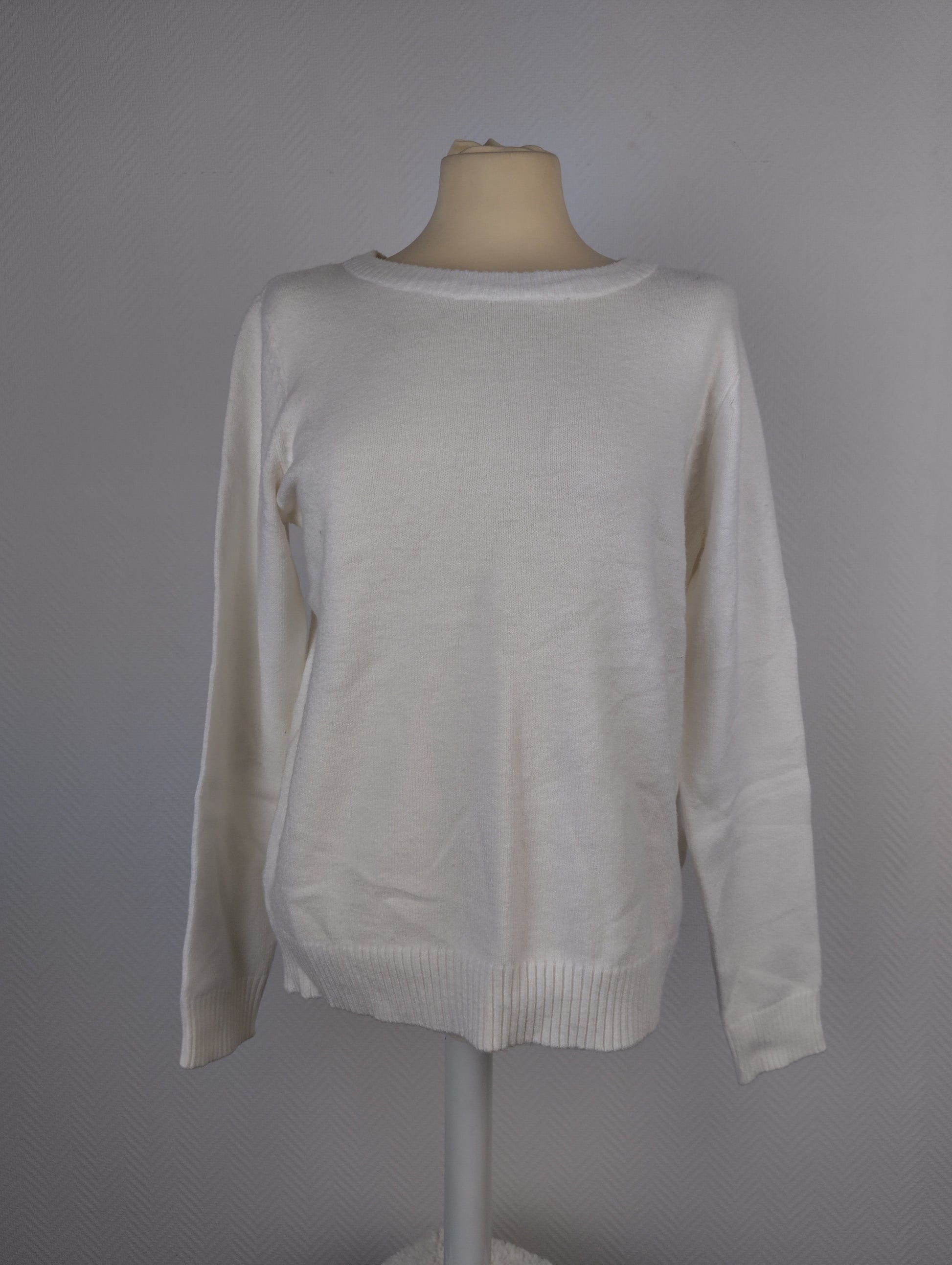 Front view of white knit sweater on a mannequin