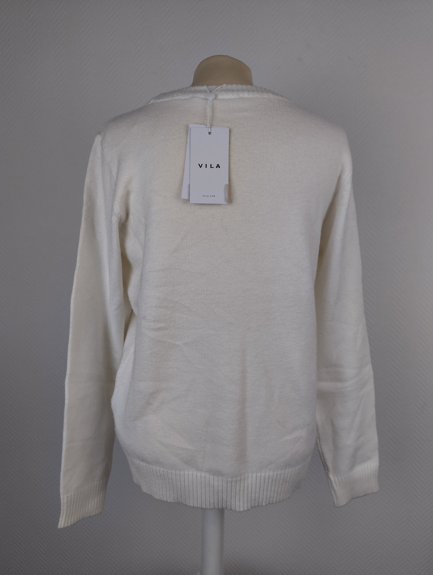Back view of white knit sweater with tag