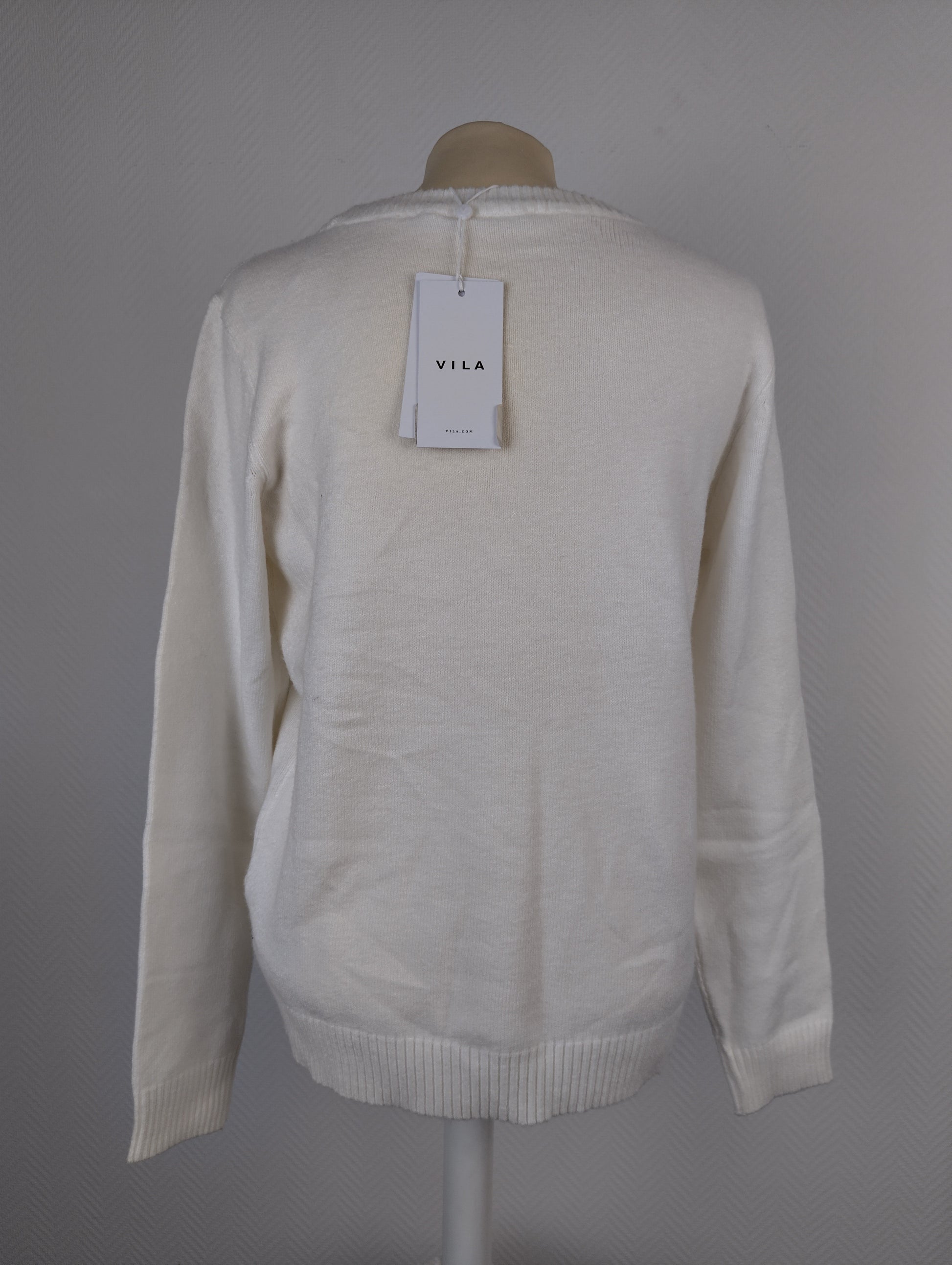 Back view of white knit sweater with tag