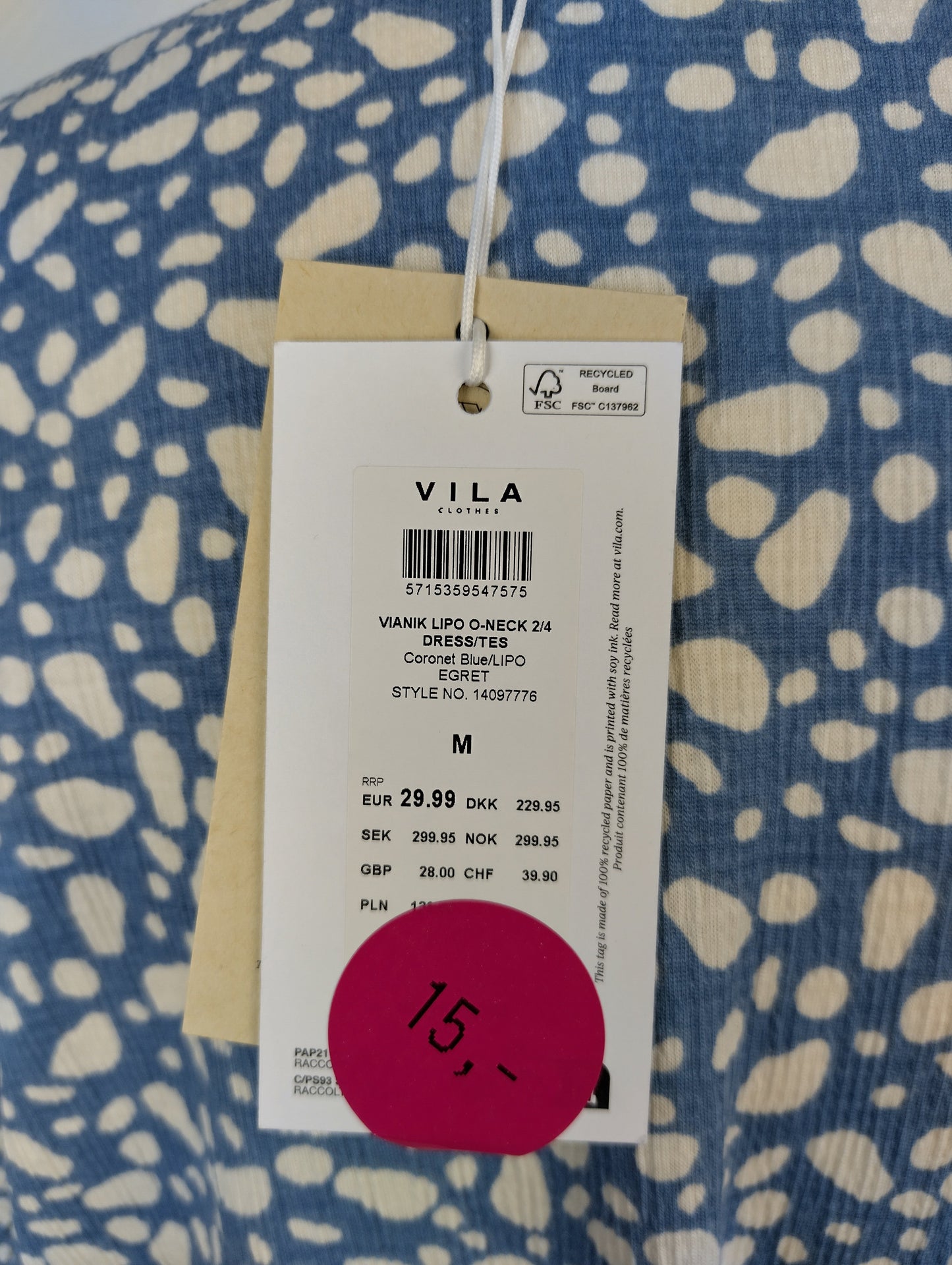 Tag on blue patterned Vila dress showing price and details