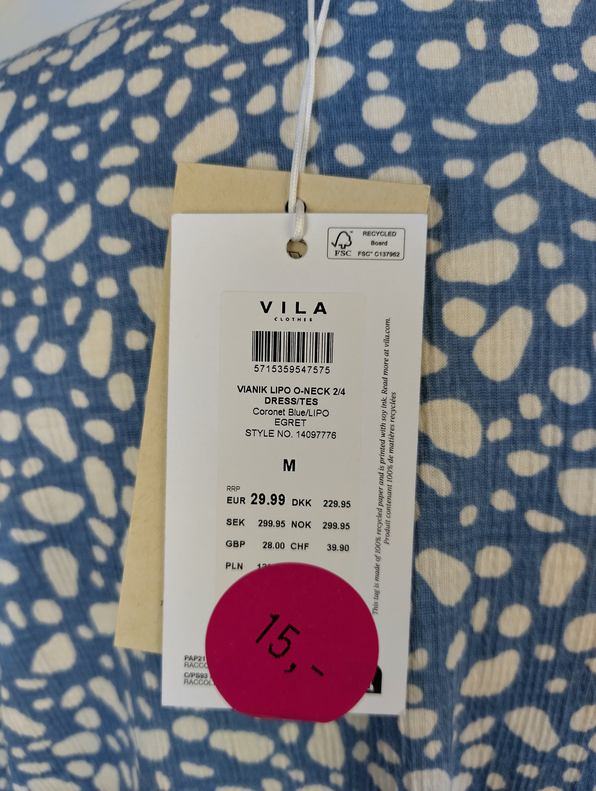 Tag on blue patterned Vila dress showing price and details