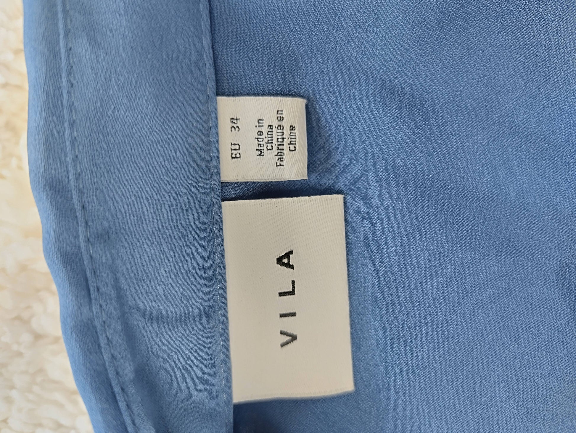 Close-up of VILA blue blouse label showing size EU 34