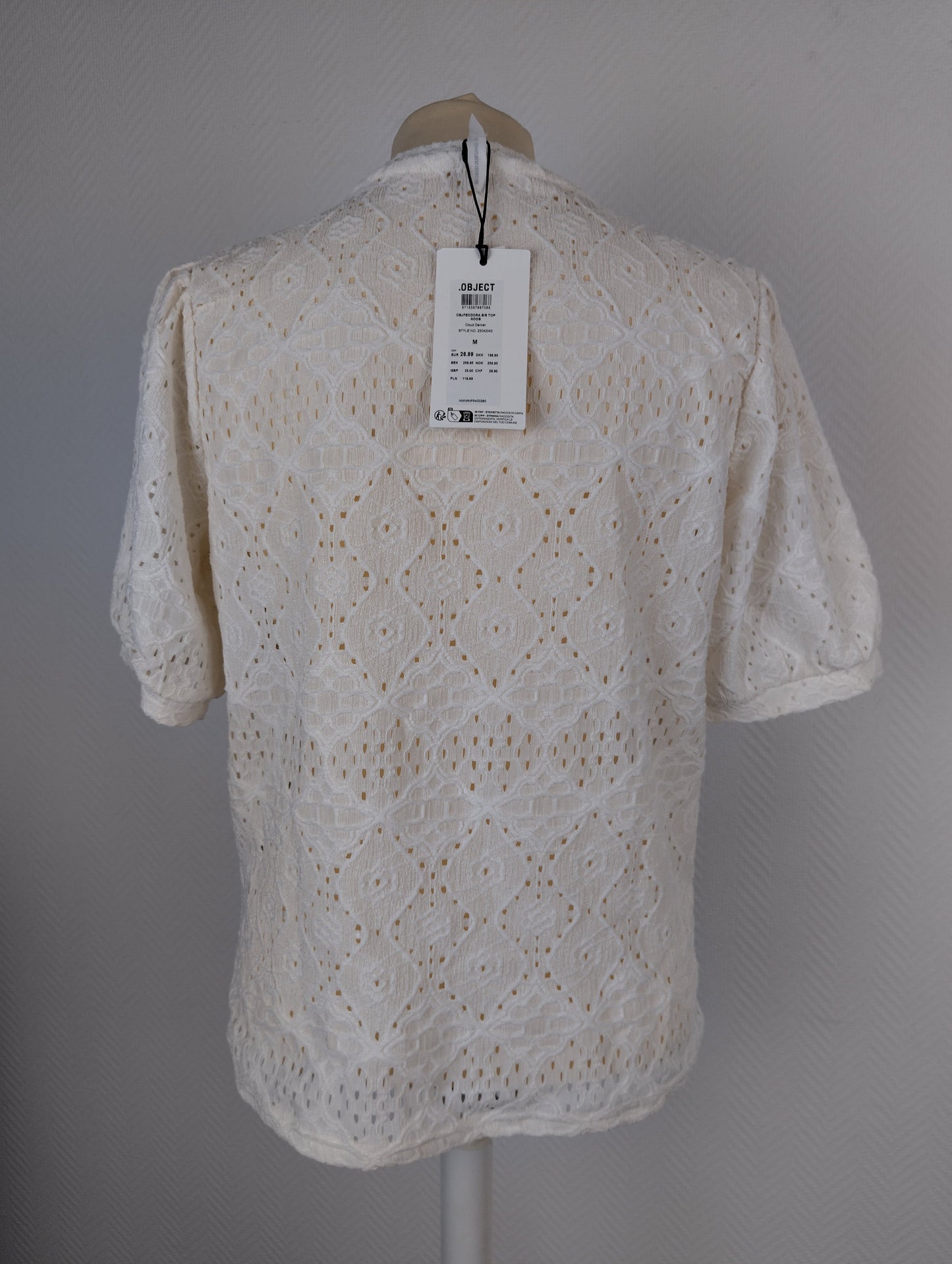Back view of white lace top with tag