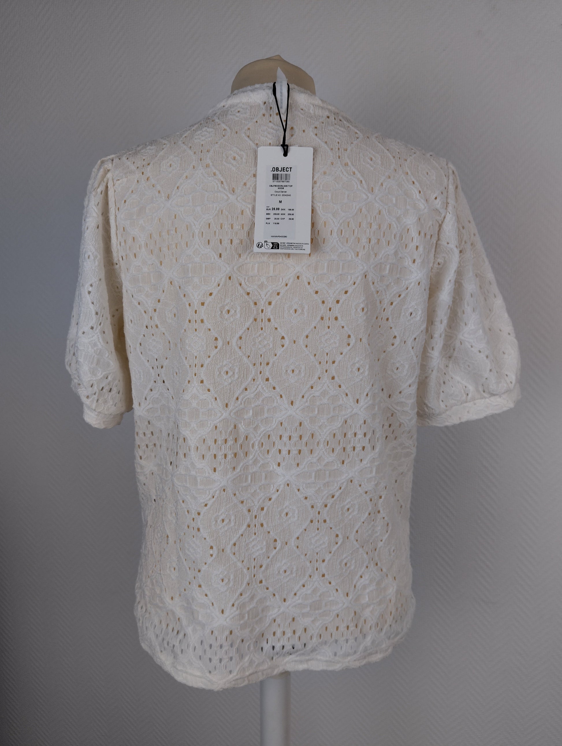 Back view of white lace top with tag