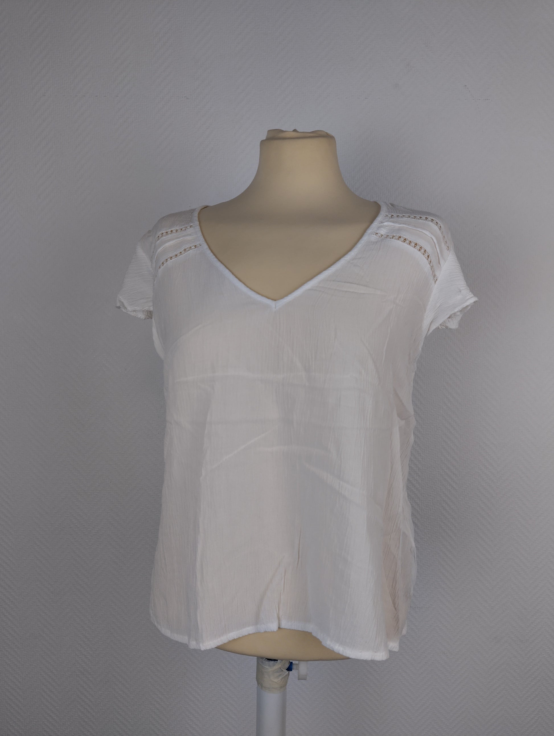 Front view of white textured blouse on mannequin