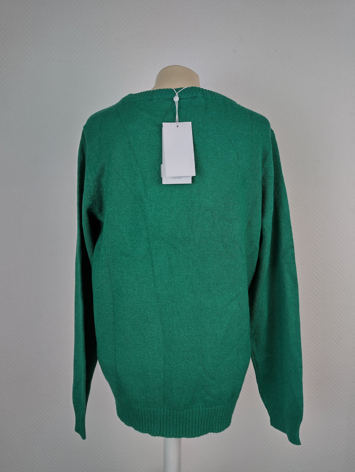 Back view of green knit sweater with tag