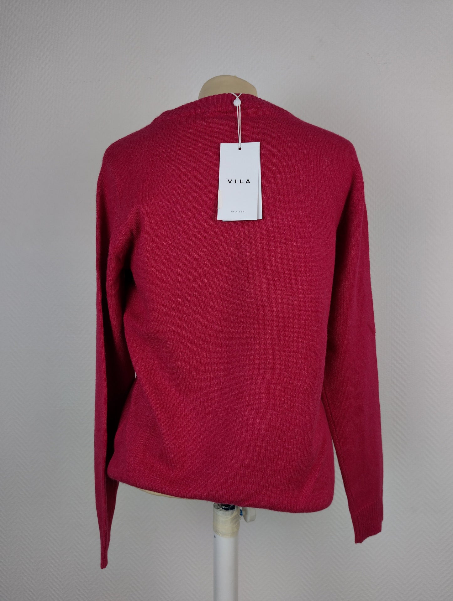 Back view of dark melon pink knit sweater with tag