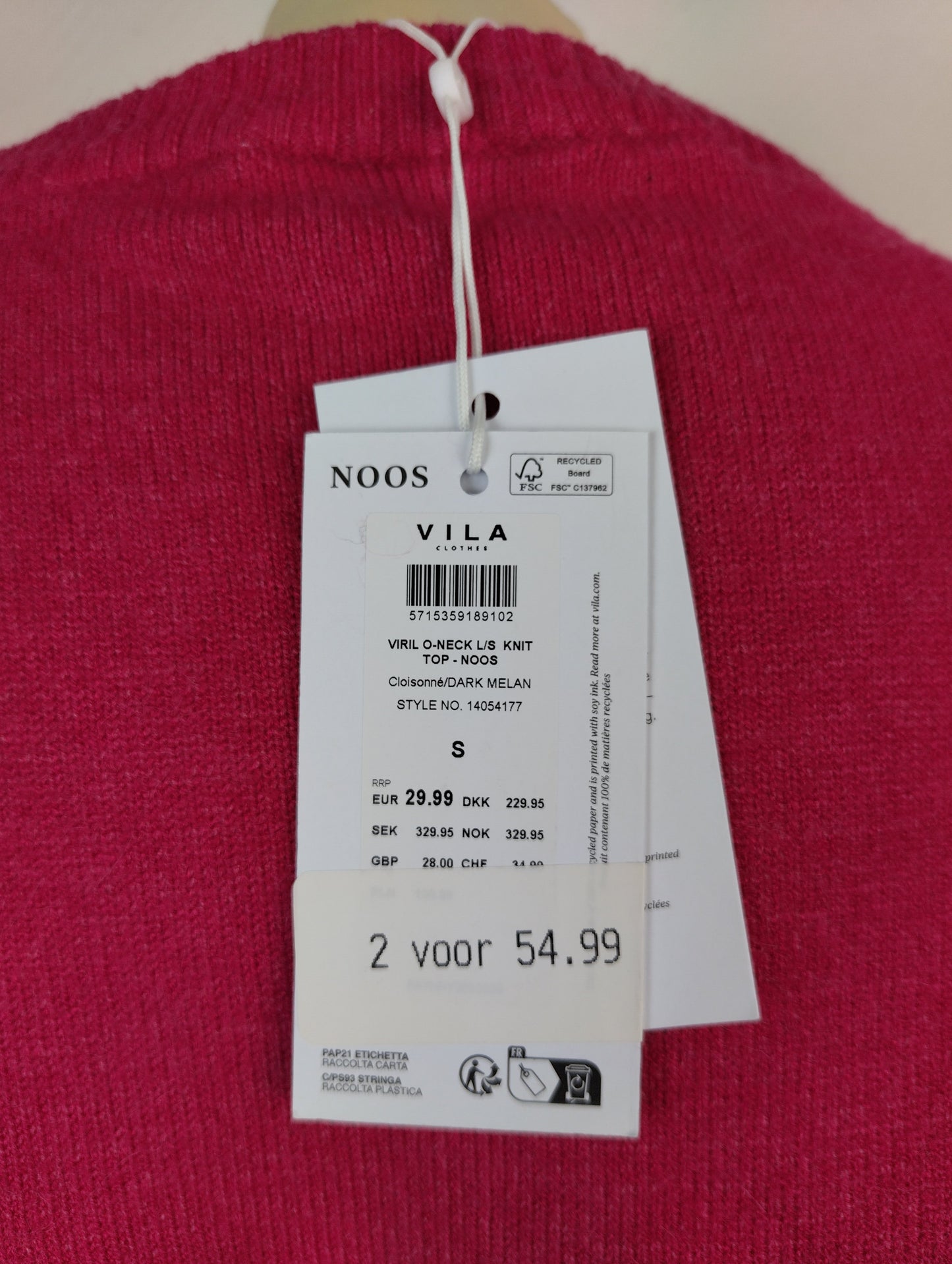 Close-up of tag on knit sweater displaying price and brand details