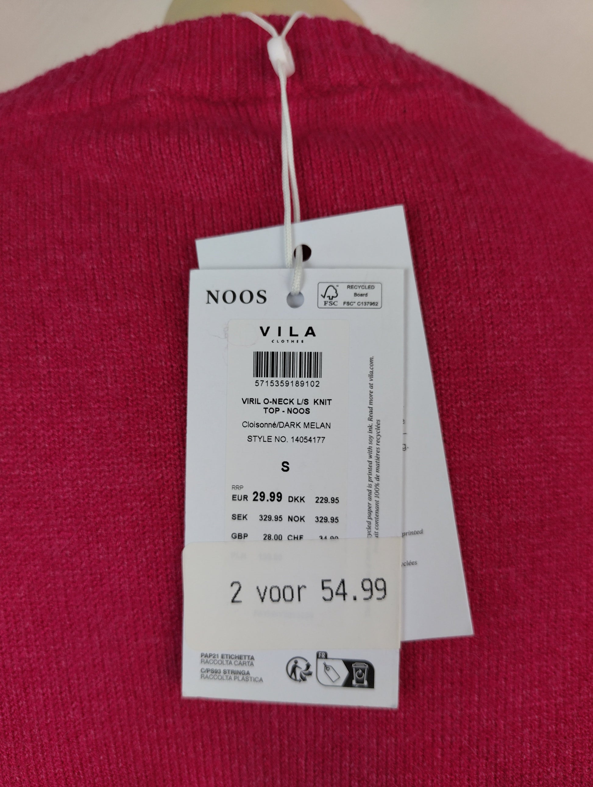 Close-up of tag on knit sweater displaying price and brand details