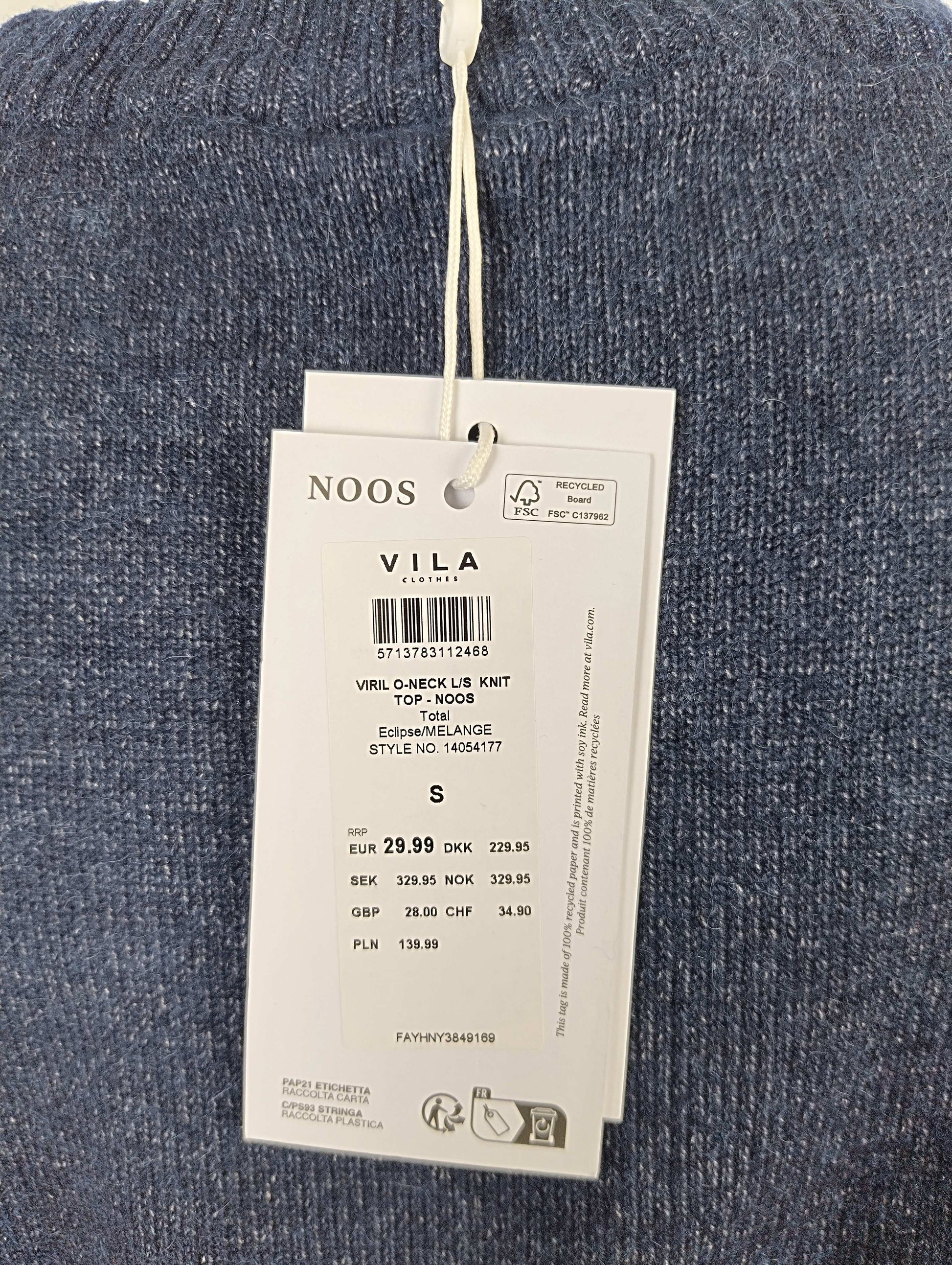 Close-up of tag details on blue knit sweater
