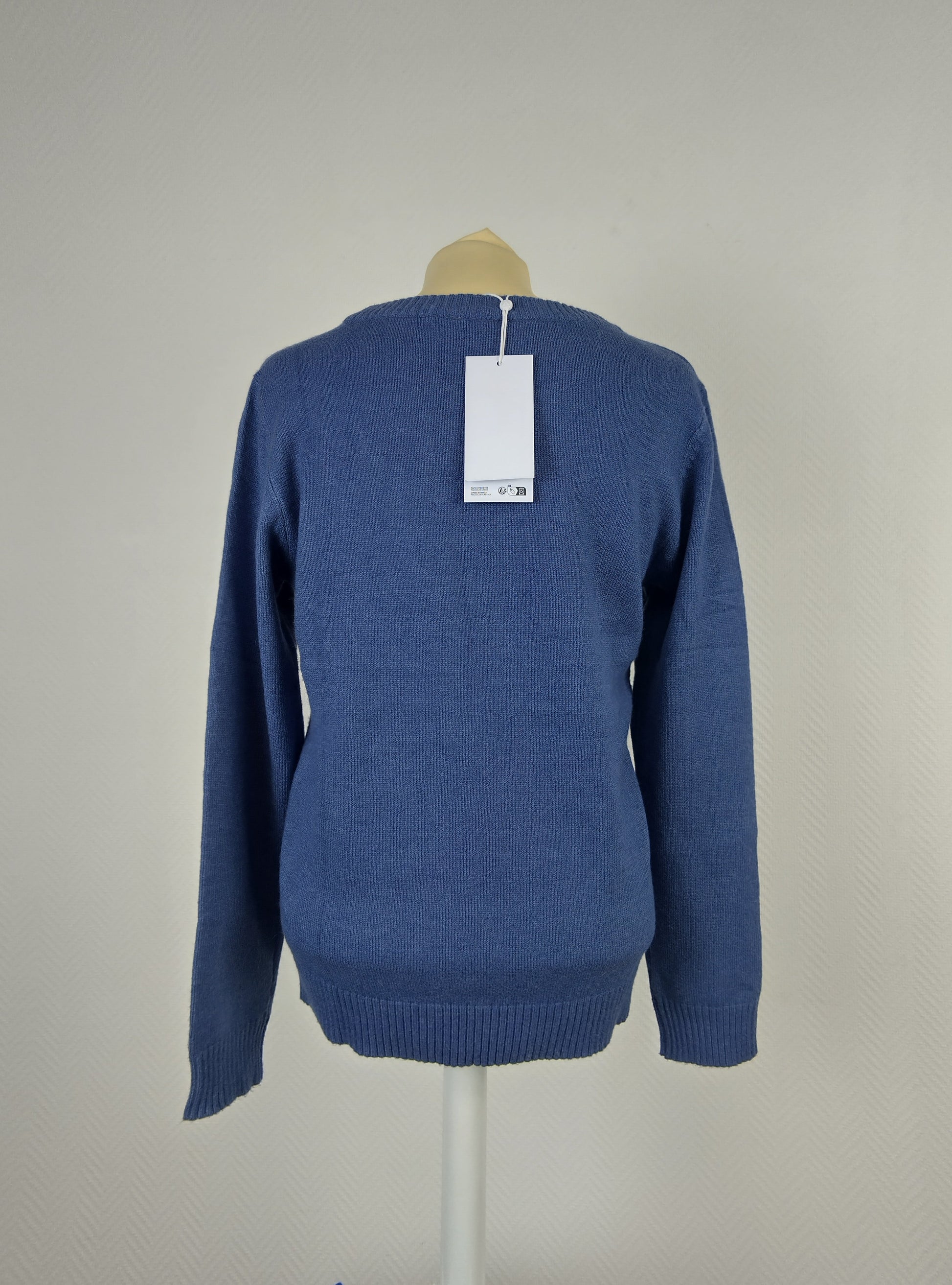 Back view of blue knit sweater with tag