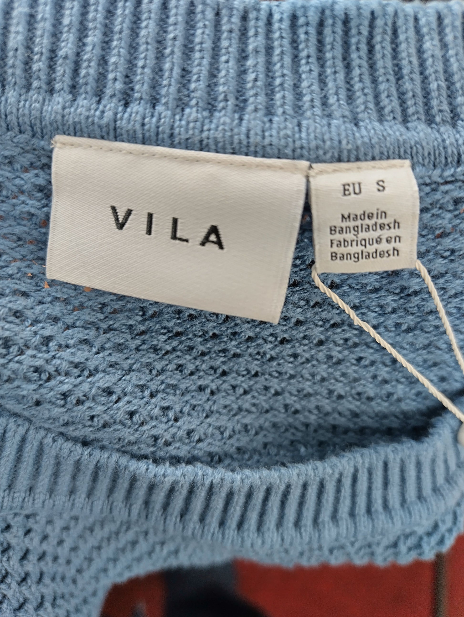Close-up of Vila brand tag and size label on sweater