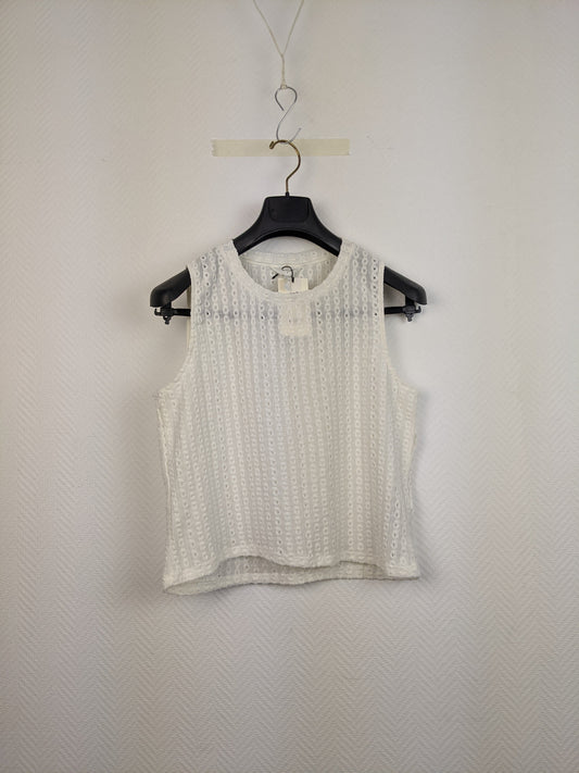 Front view of white eyelet sleeveless top on hanger